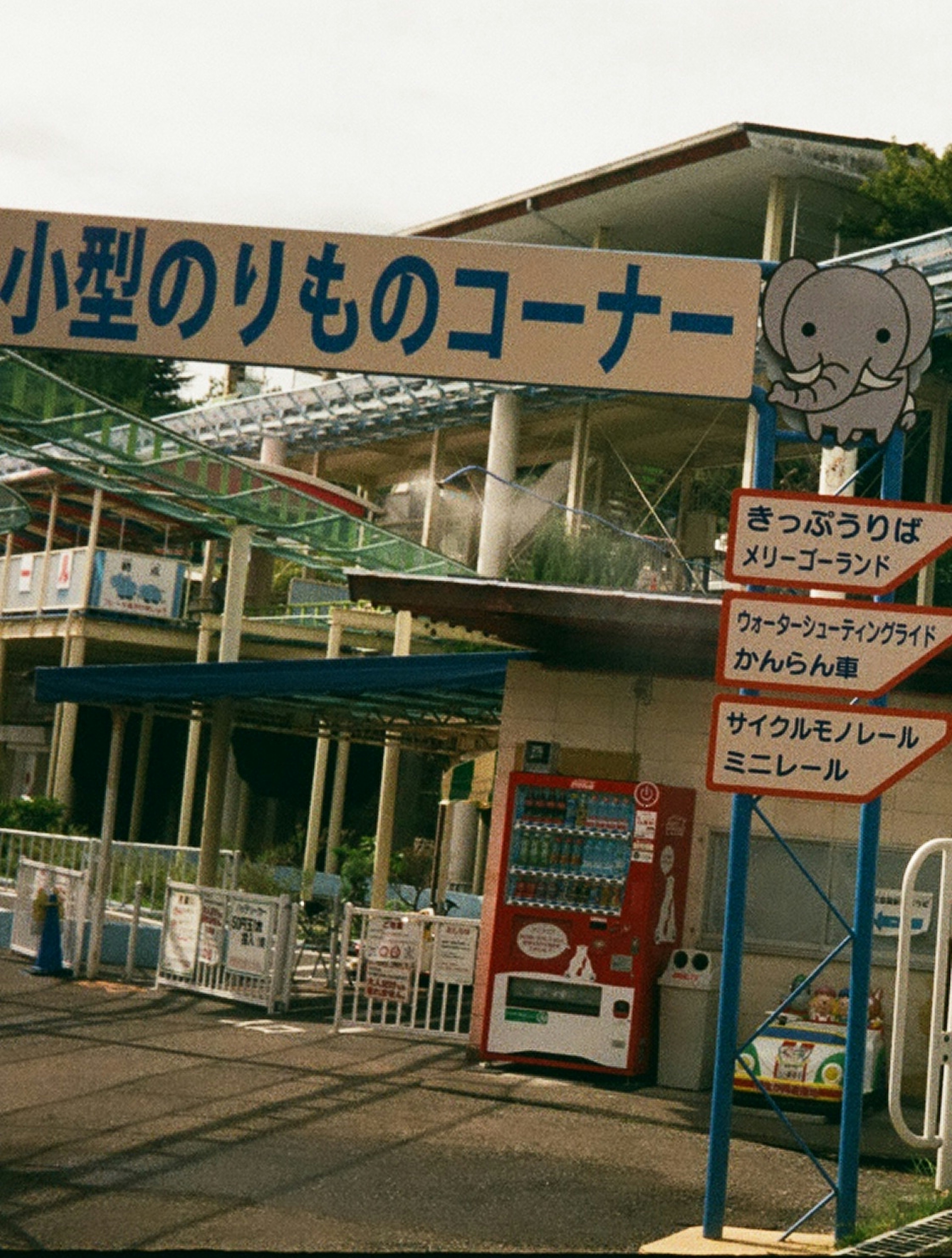 小型のりものコーナーの看板と遊園地の風景