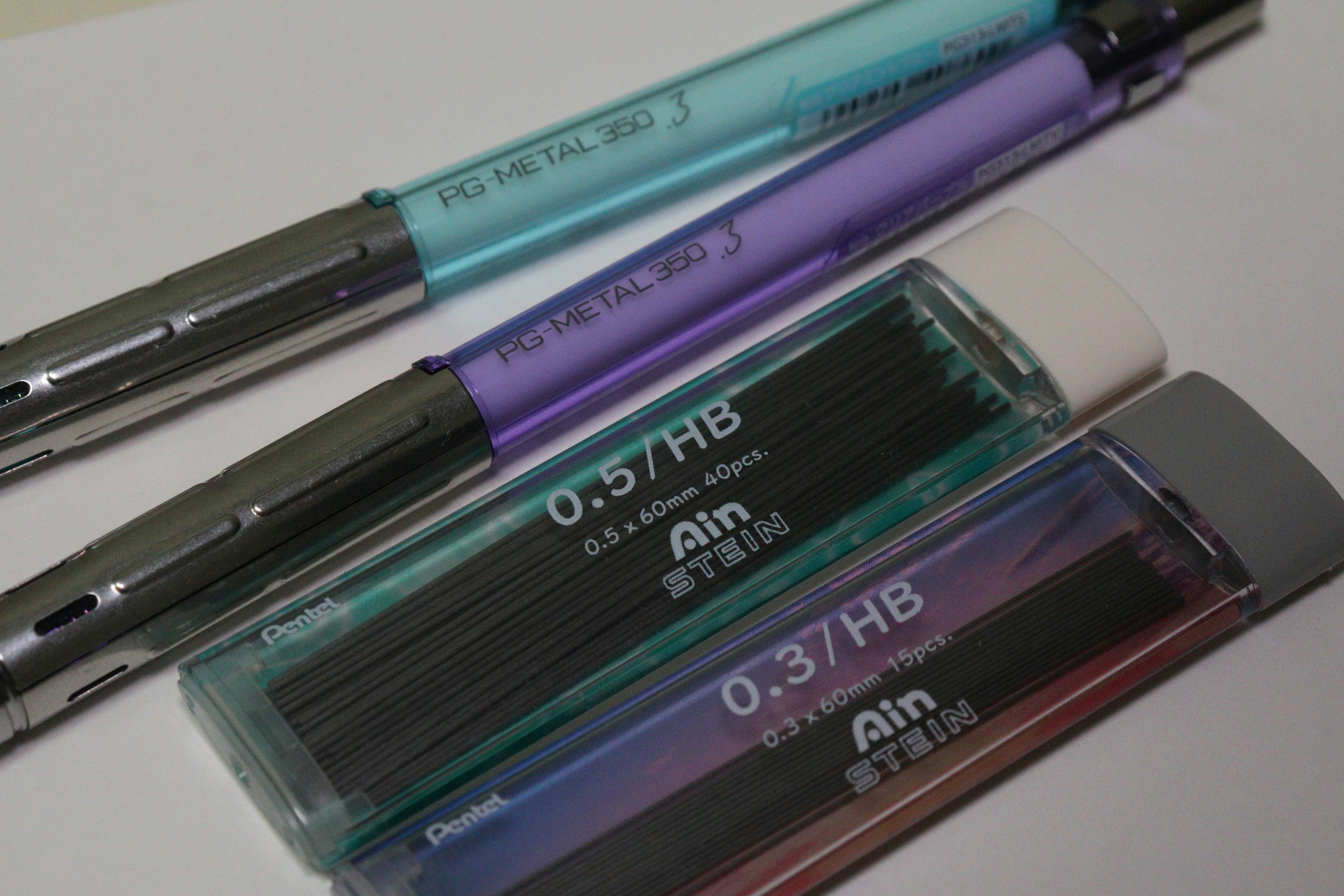 Image of blue and purple pens alongside an eraser and lead refills