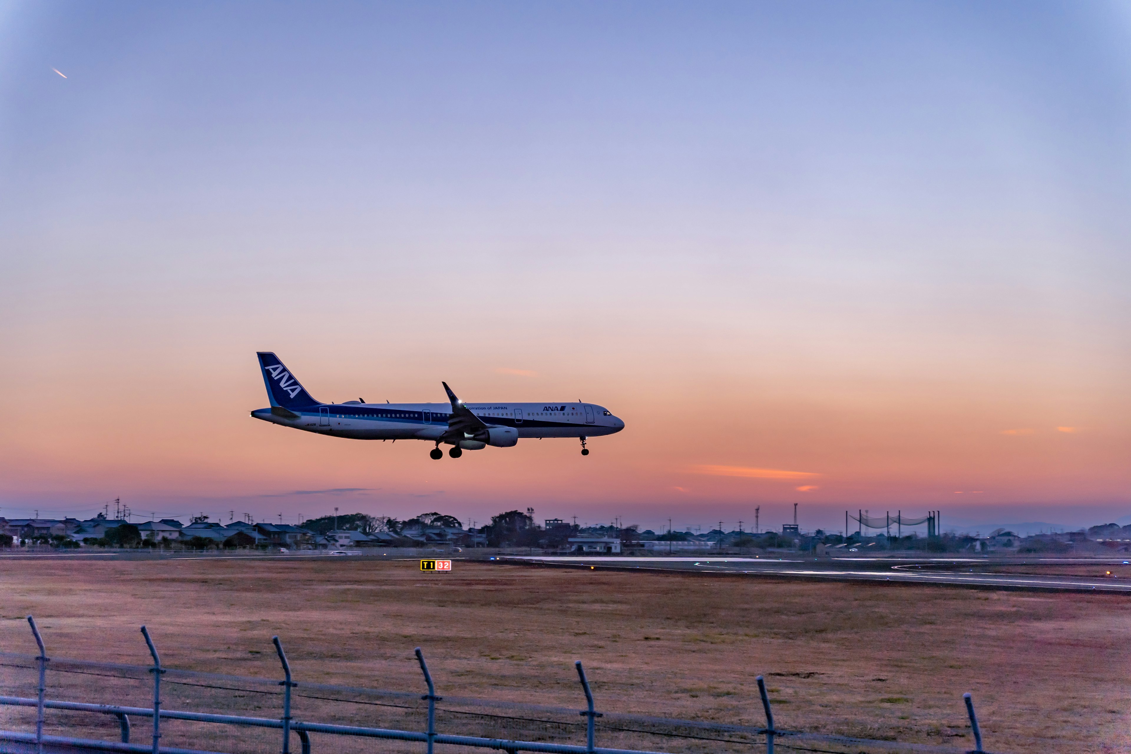 Avión de pasajeros volando durante el atardecer sobre la pista