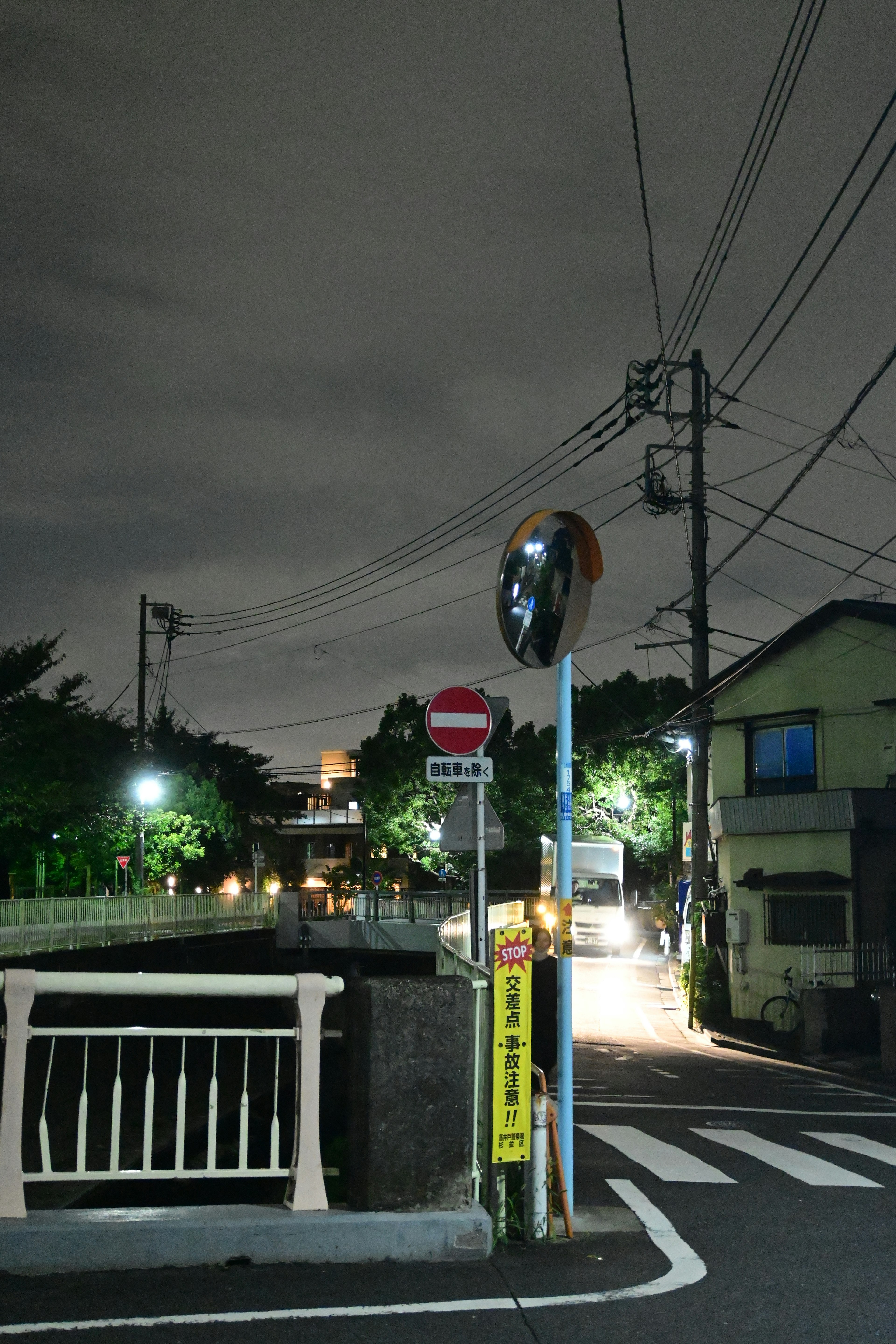 夜の街角にある信号機とミラーが映る風景