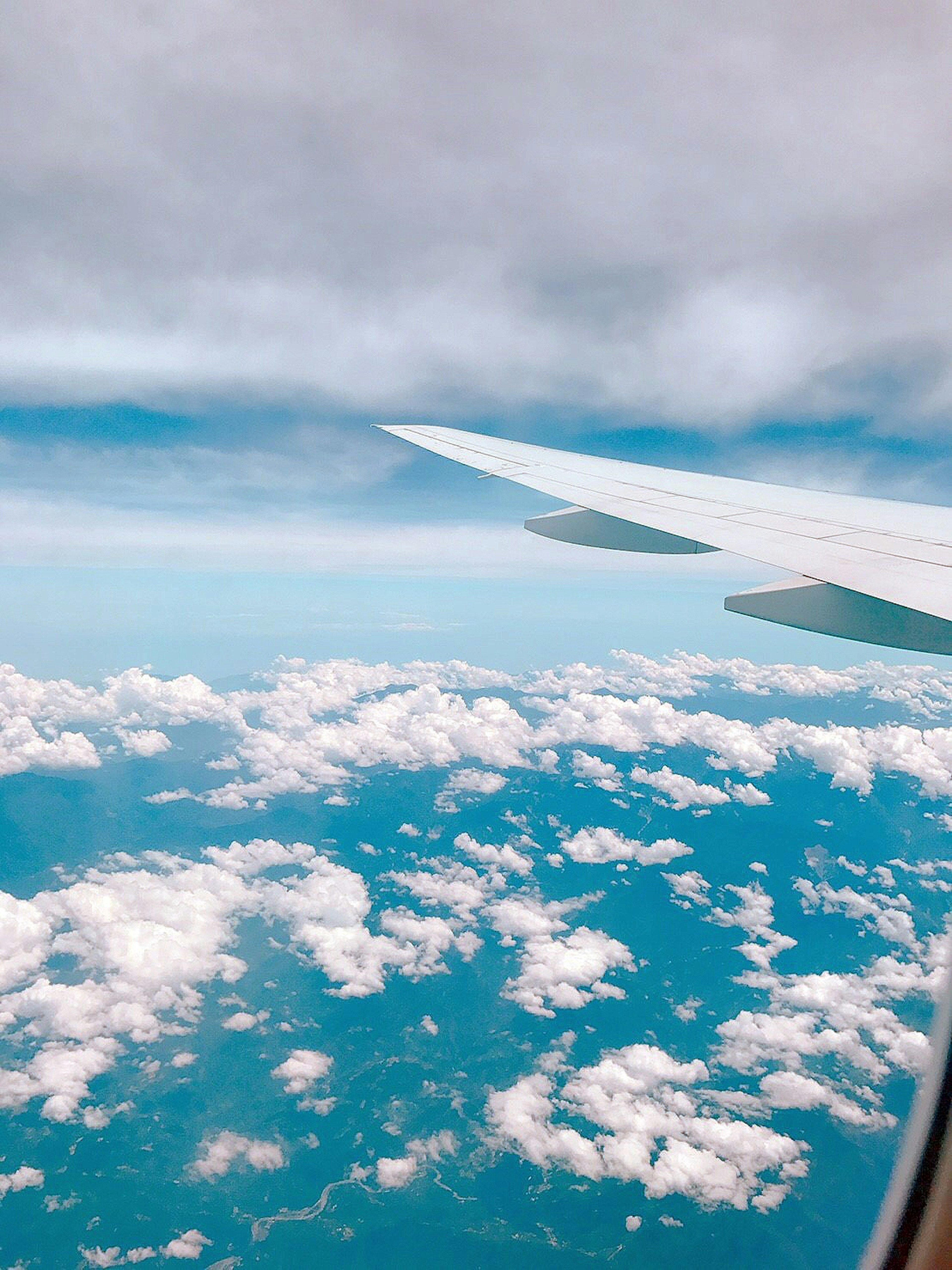 Vista de un ala de avión con cielo azul y nubes blancas