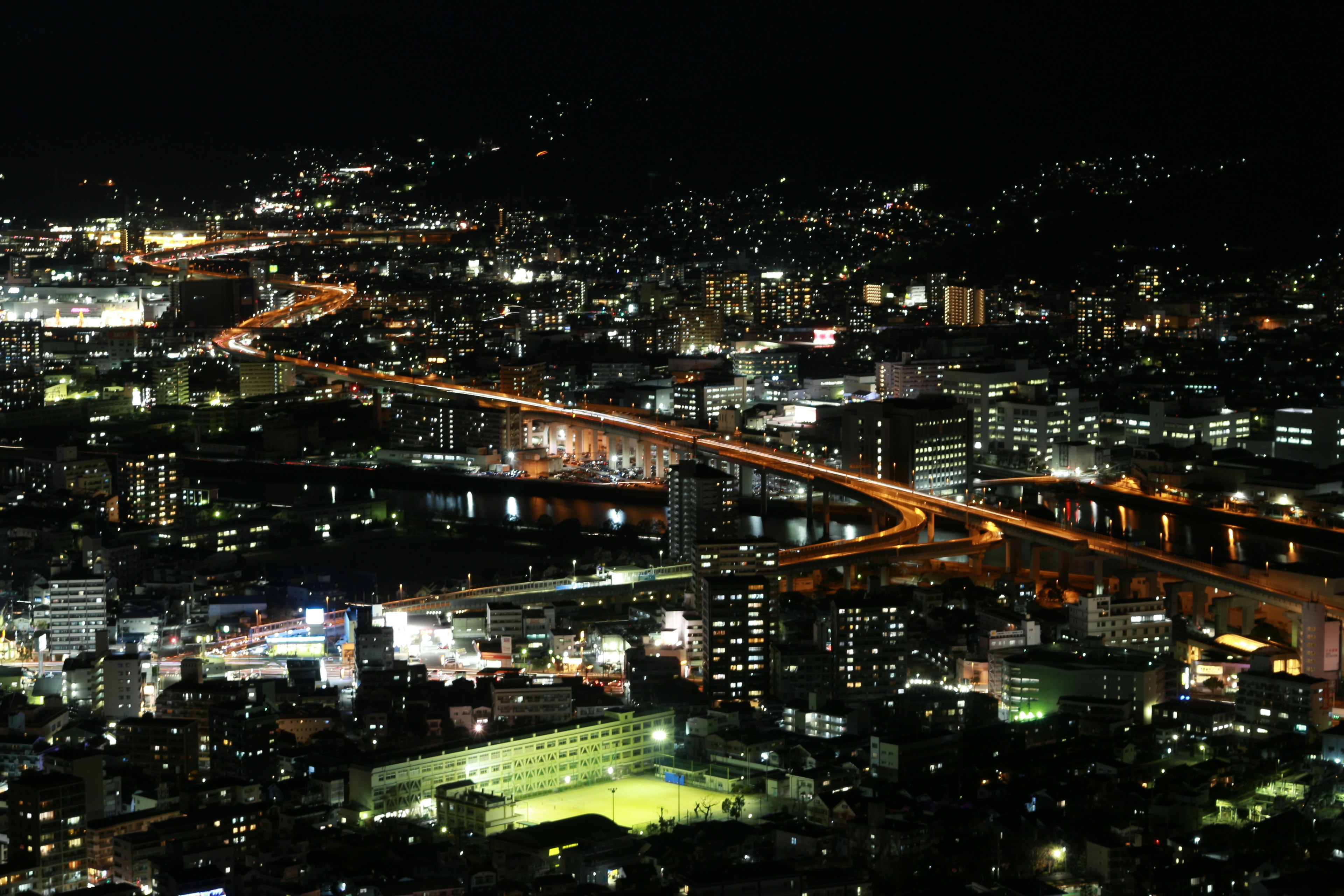 Paesaggio urbano notturno con strade illuminate e luci degli edifici