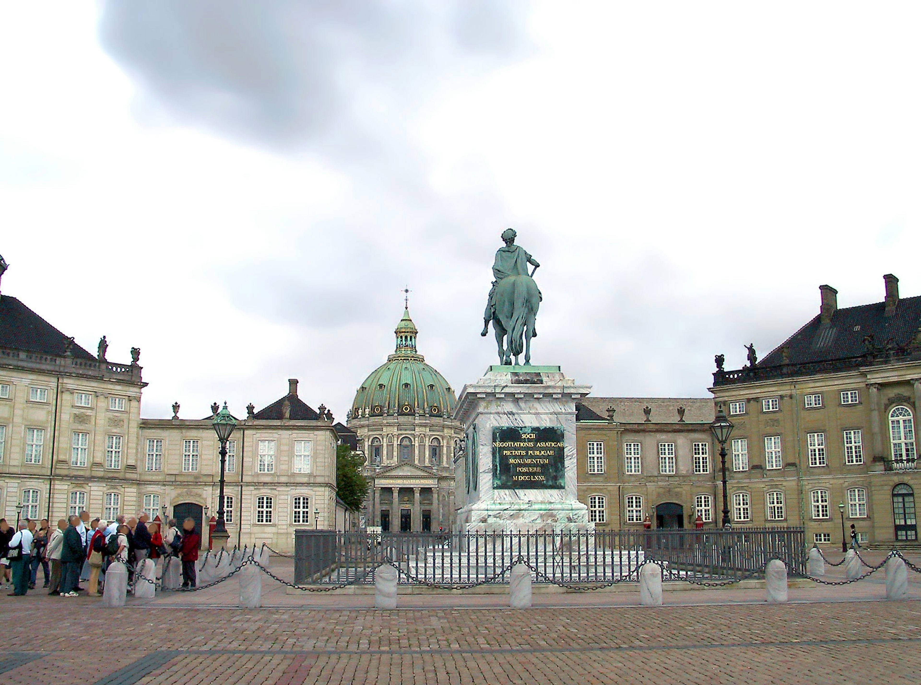 Statue of a king in front of Amalienborg Palace with tourists