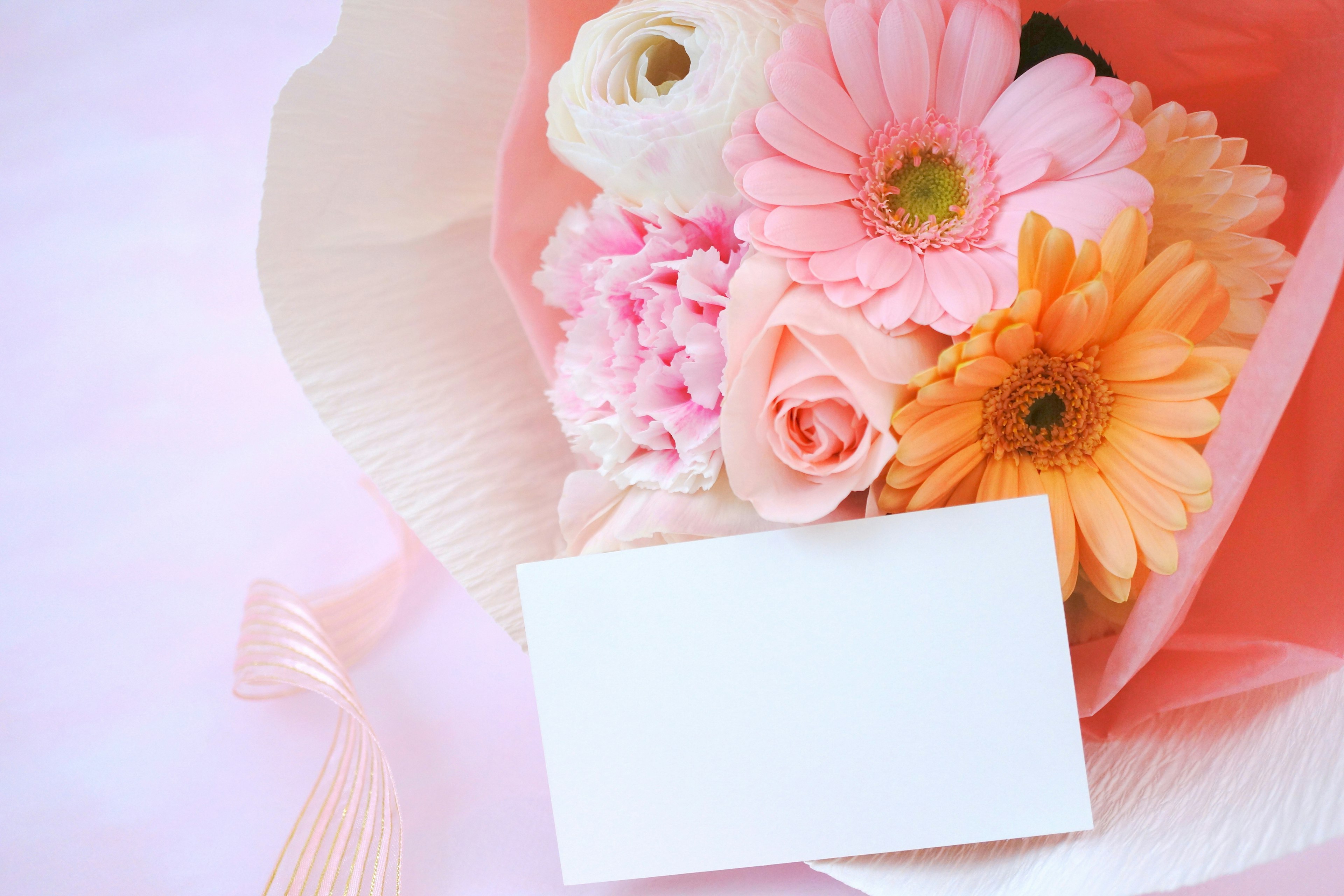 Un ramo de flores rosas con una tarjeta de mensaje en blanco