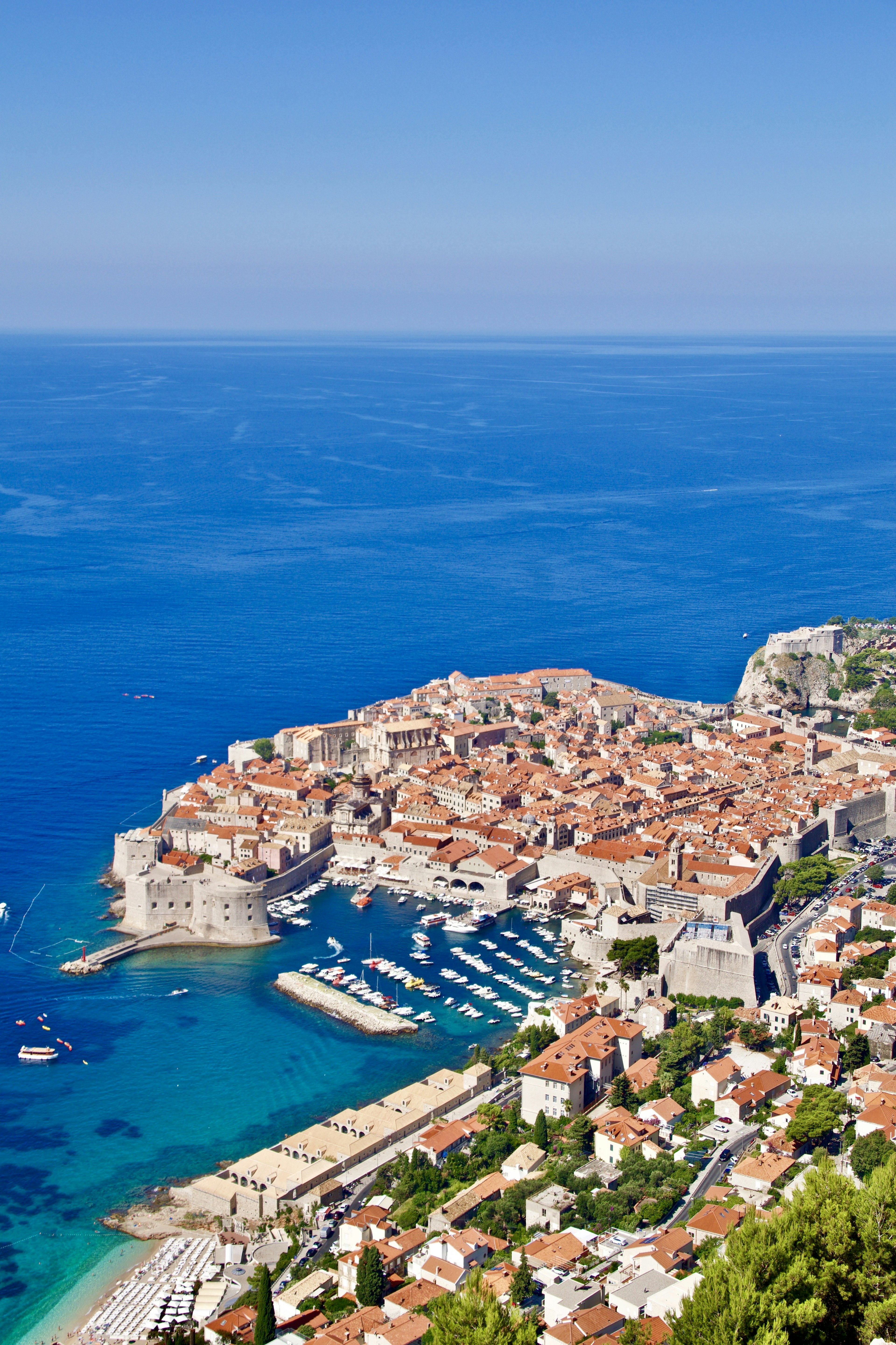 Luftaufnahme von Dubrovnik mit orangefarbenen Dächern und klarem blauen Wasser