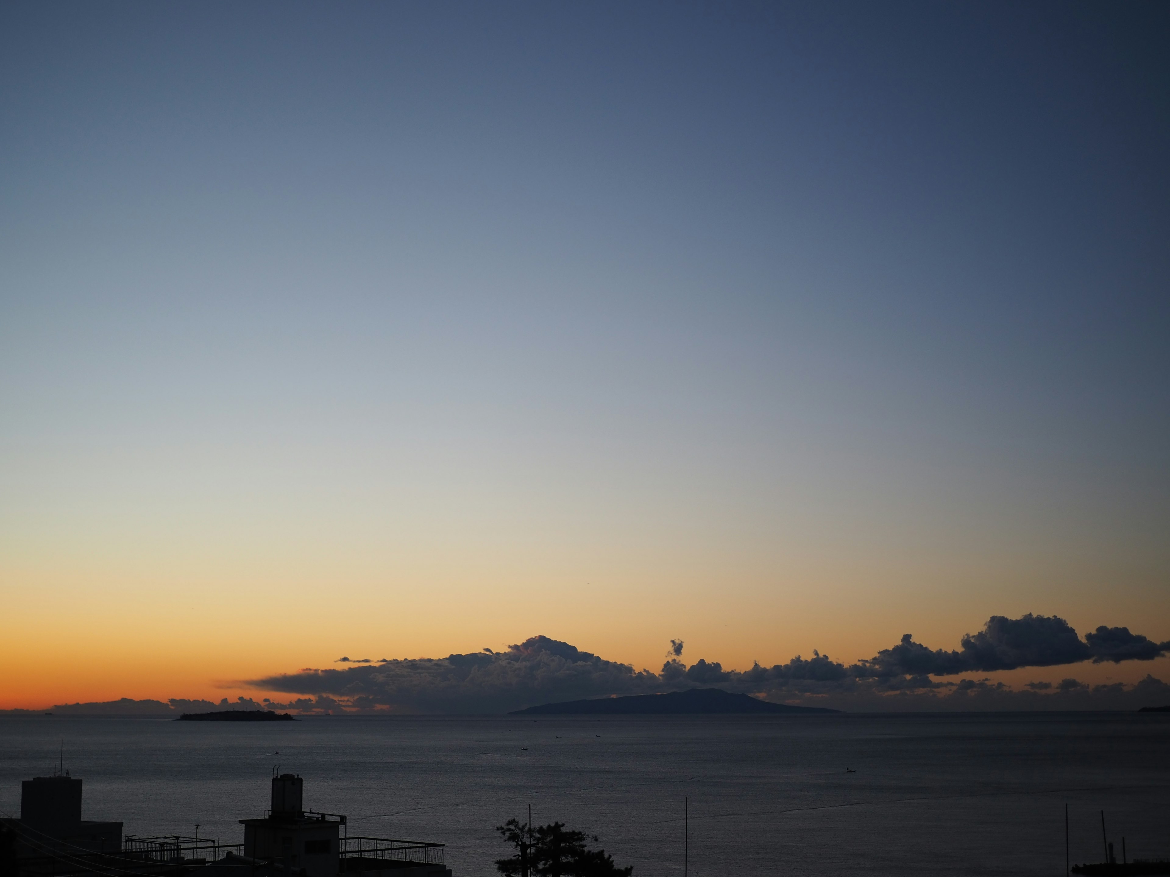 Coucher de soleil sur l'océan avec des montagnes en arrière-plan