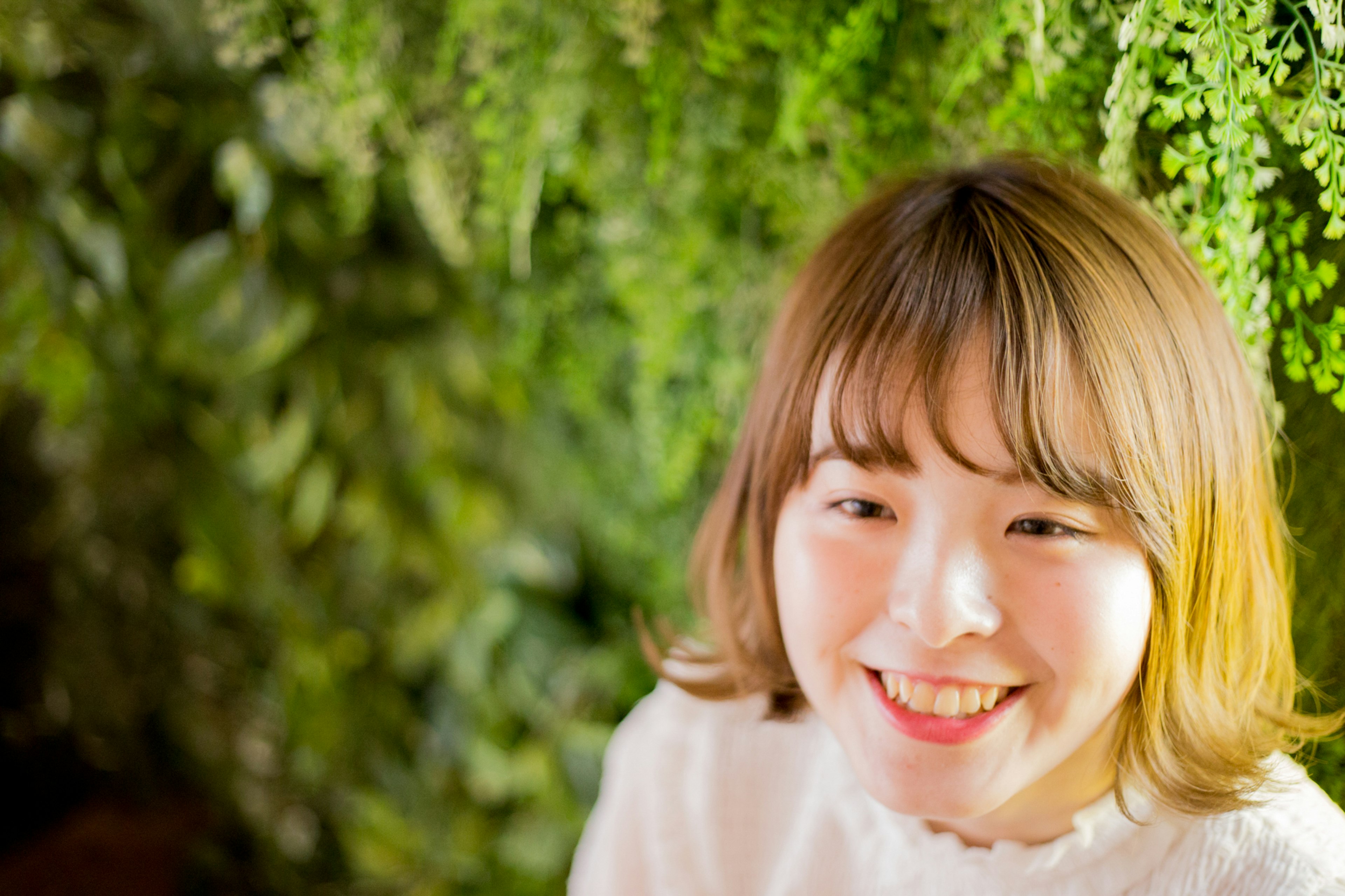 緑の背景の前で微笑む女性のポートレート