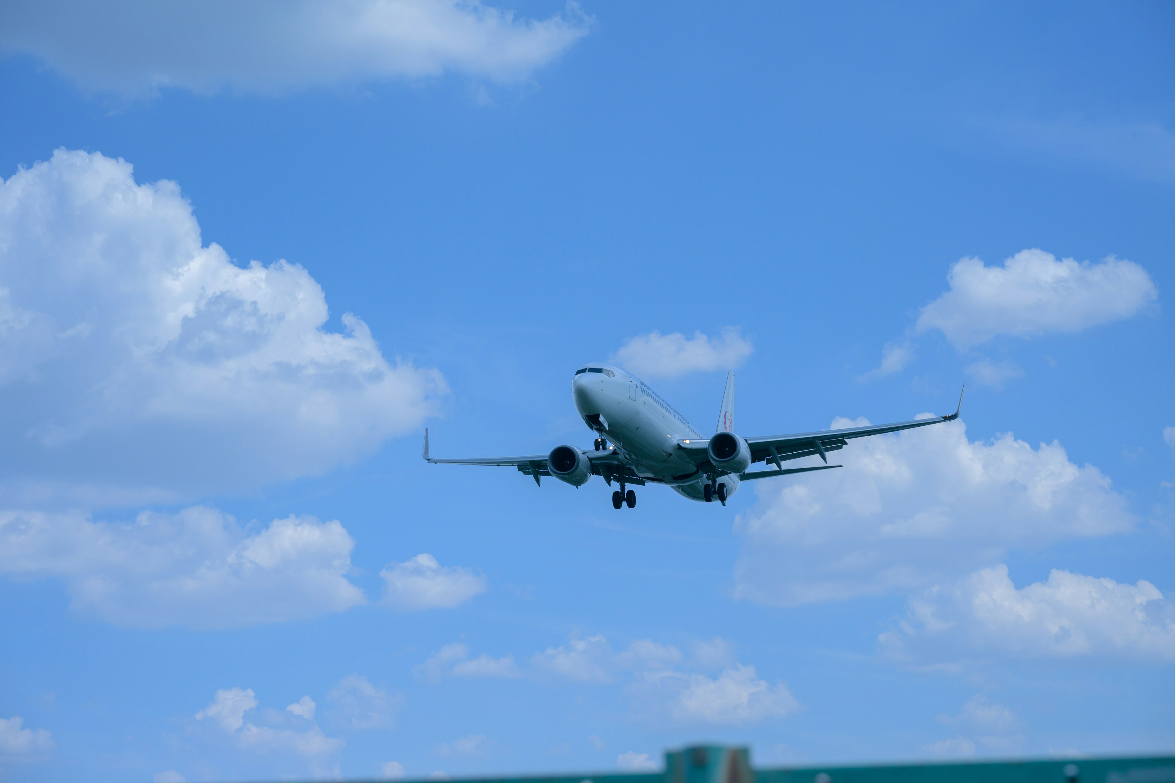 Un avión volando en un cielo azul con nubes