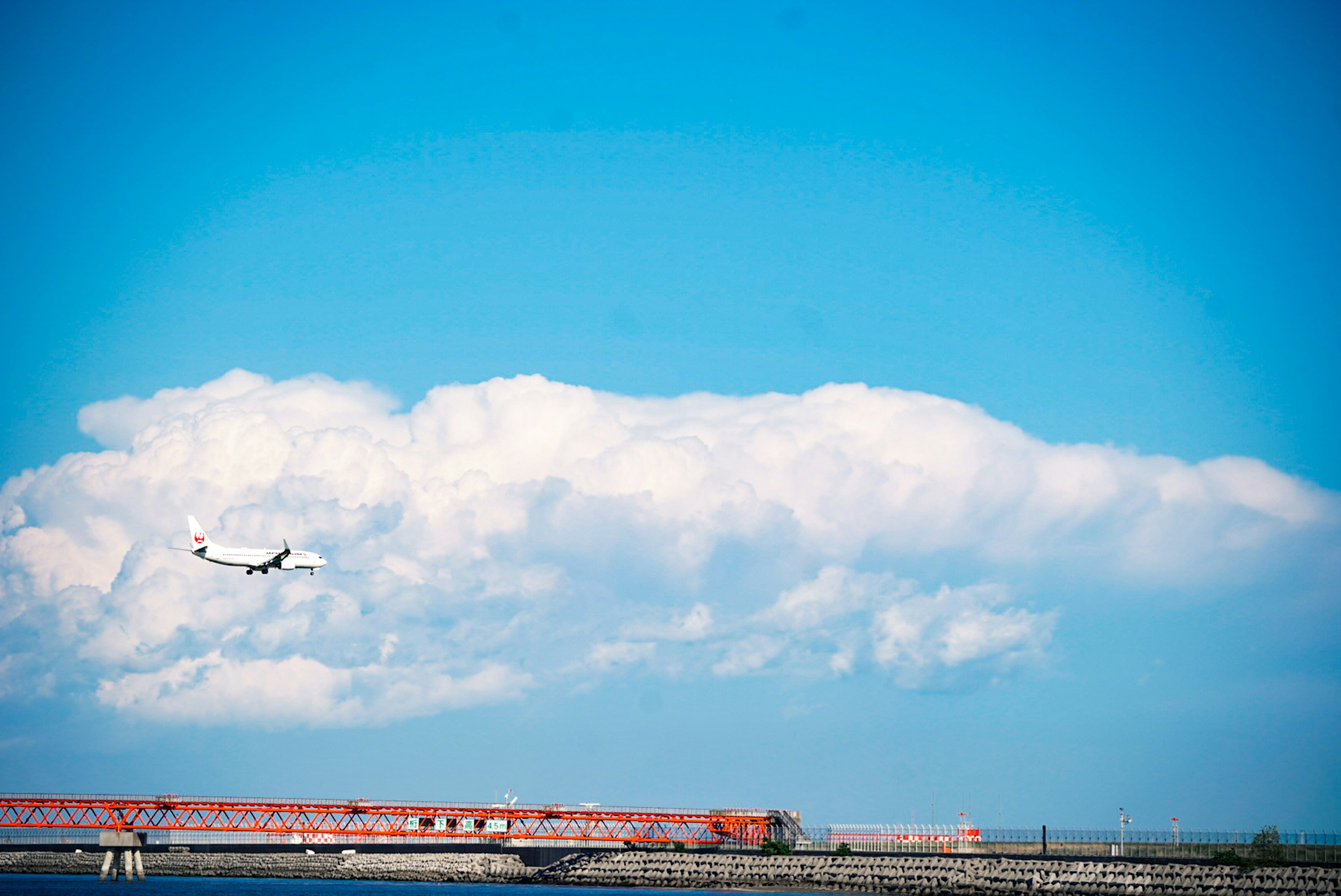 青空に飛行機が飛んでいる風景と白い雲