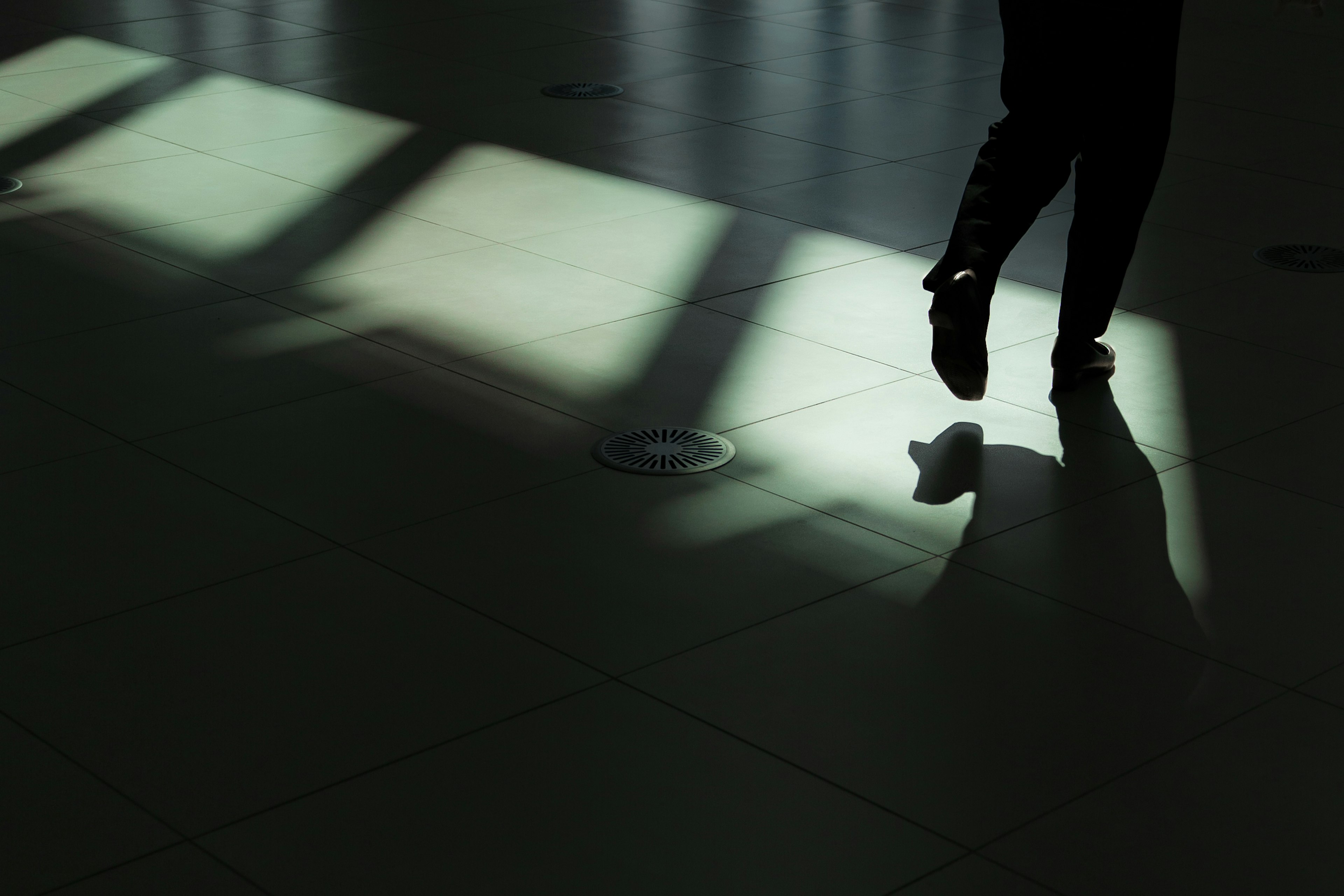 Silhouette of a person walking with light patterns on the floor