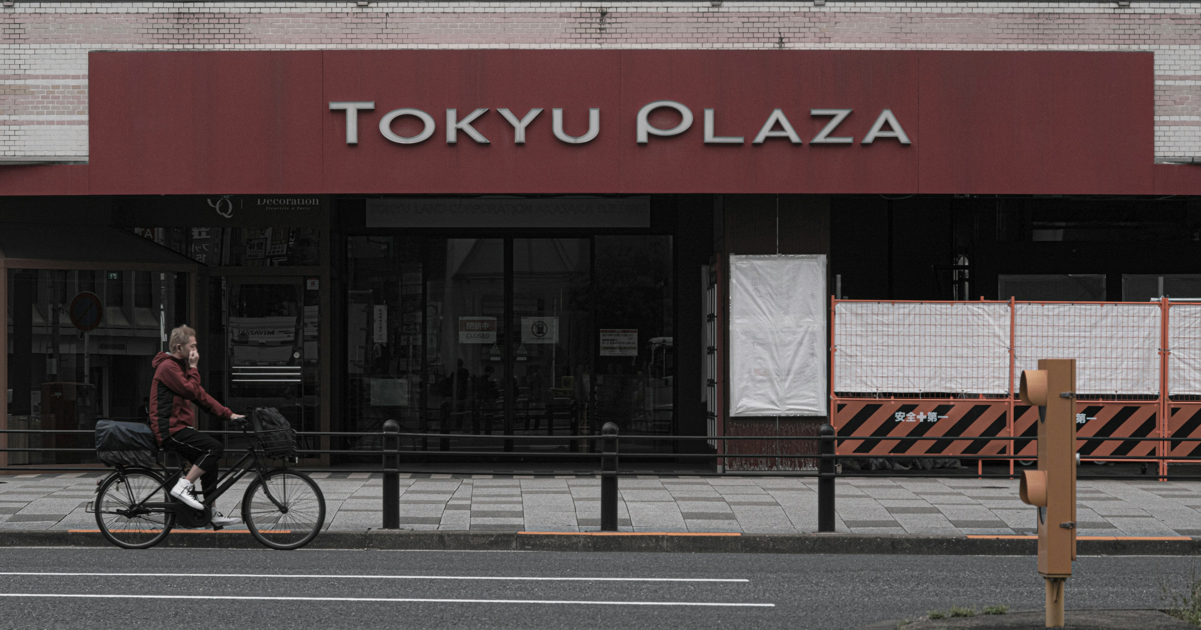 Persona montando en bicicleta frente al exterior de Tokyu Plaza