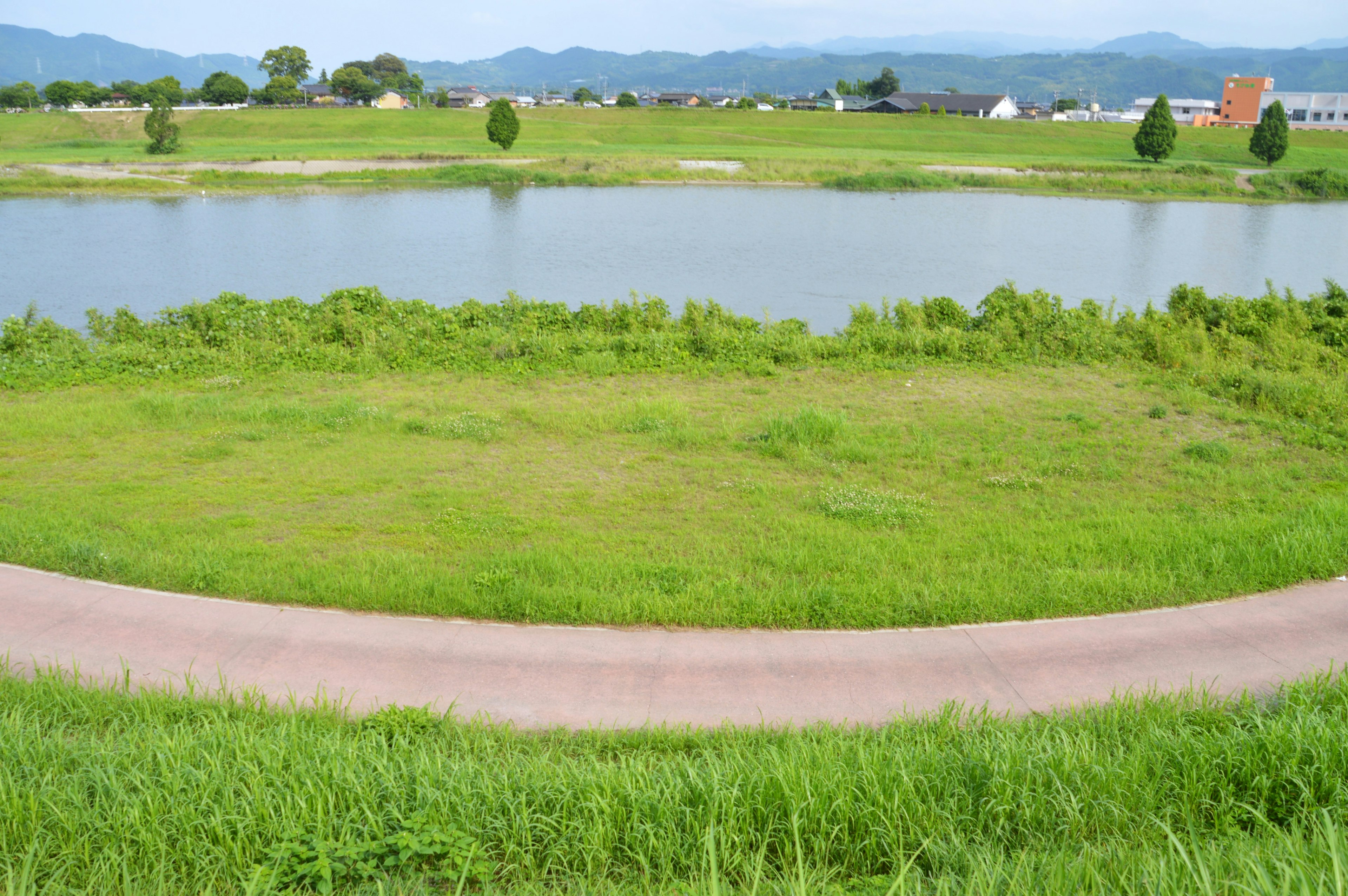 Lush green landscape with a lake Curved pathway surrounding the water