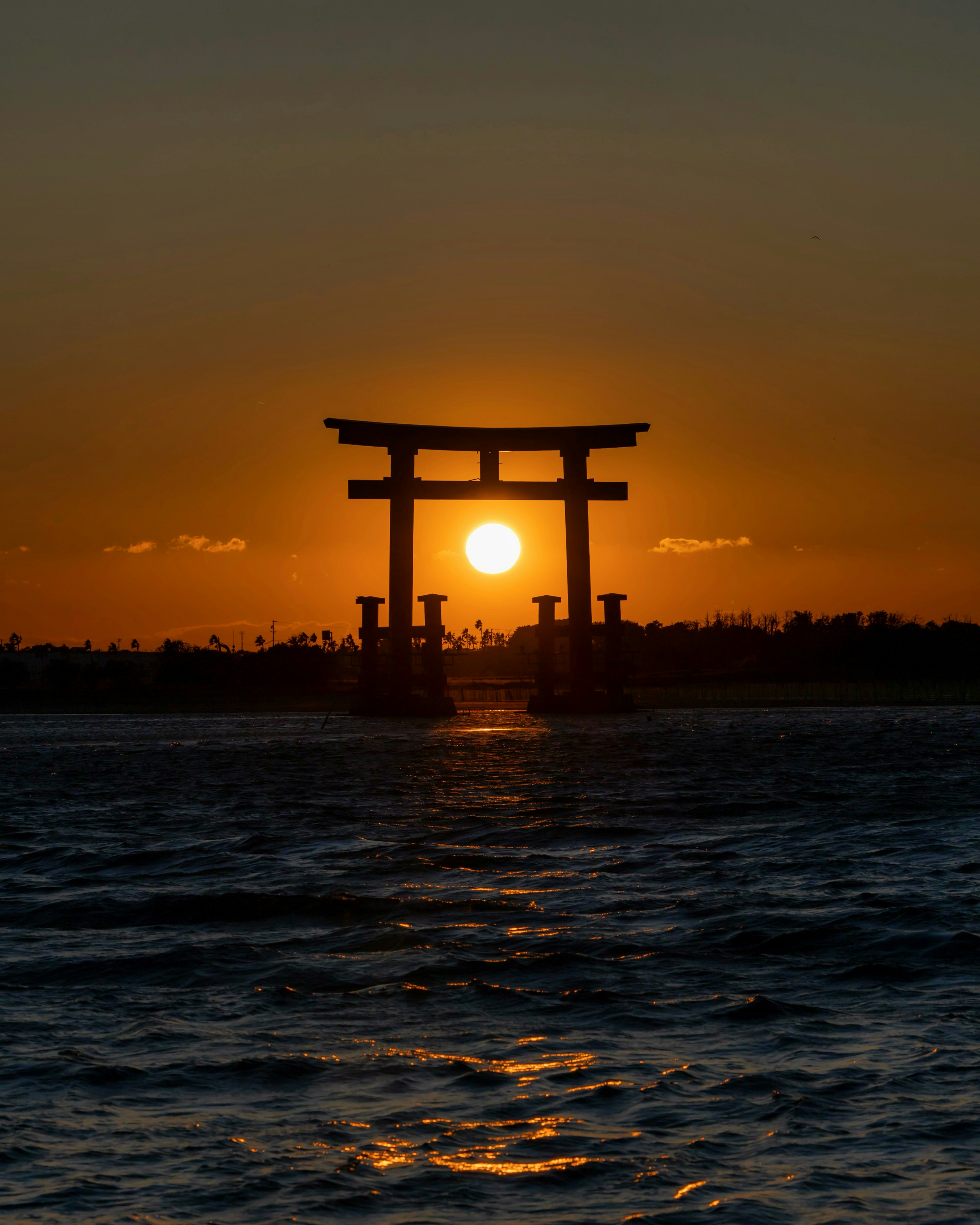 海の中に立つ鳥居と夕日が美しい風景