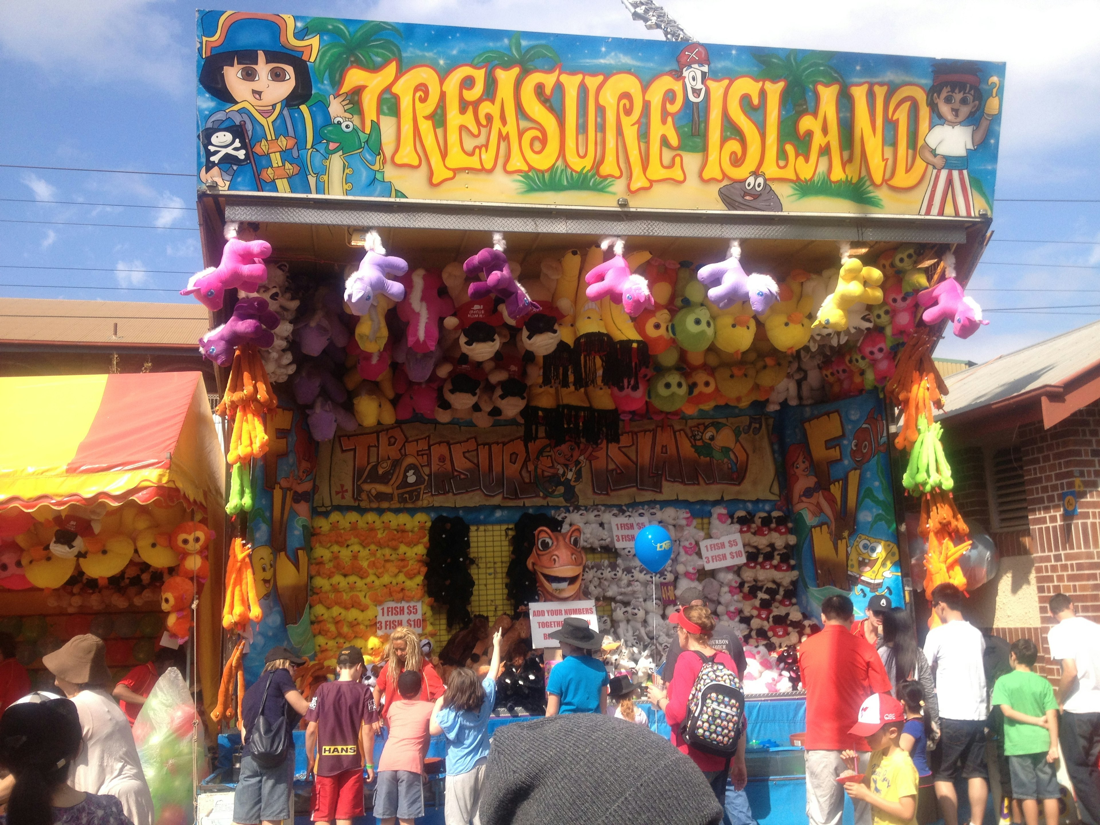 Colorful game booth named Treasure Island with children gathered around