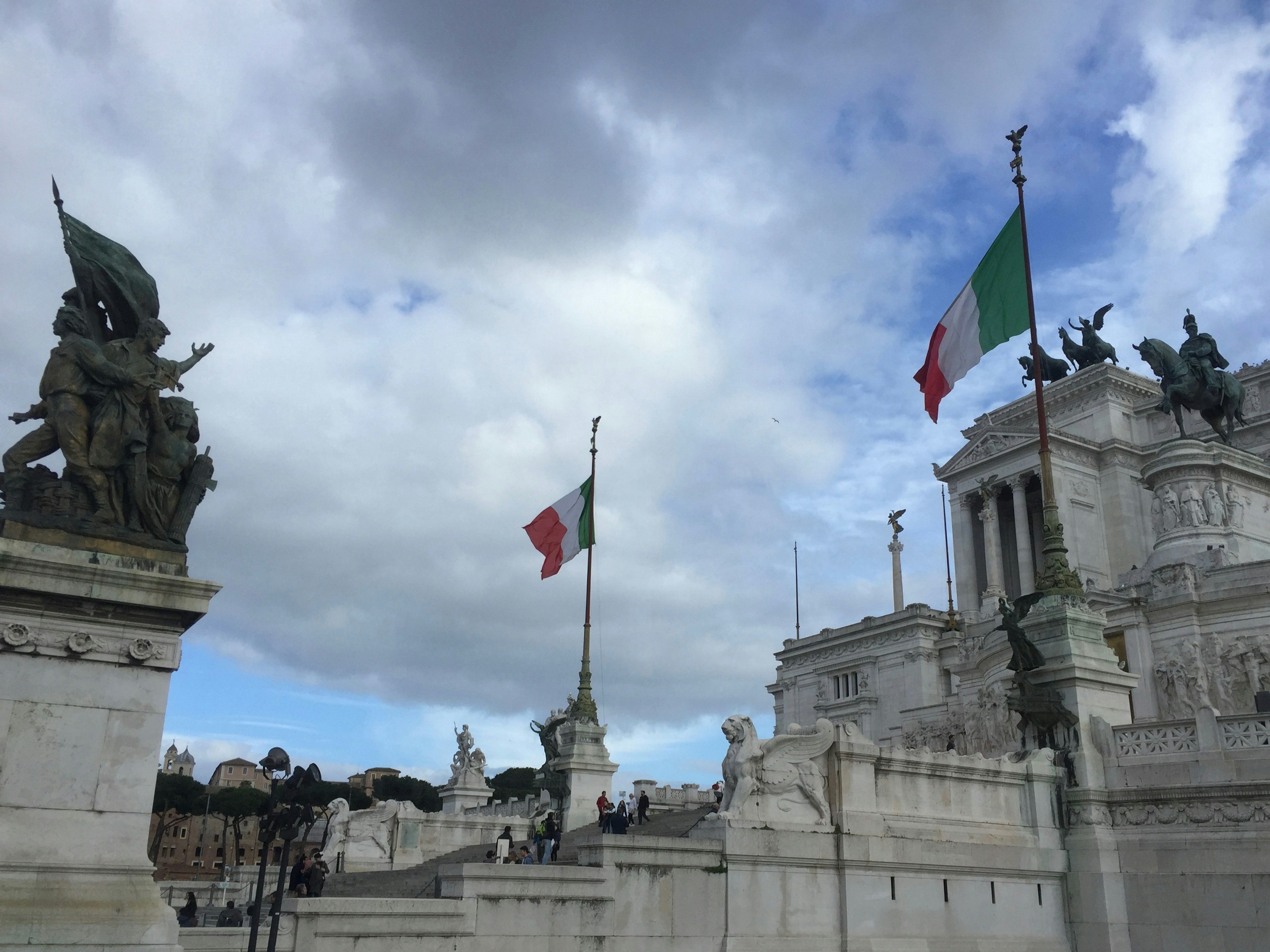 Vista del monumento Vittoriano en Roma con banderas italianas y estatuas