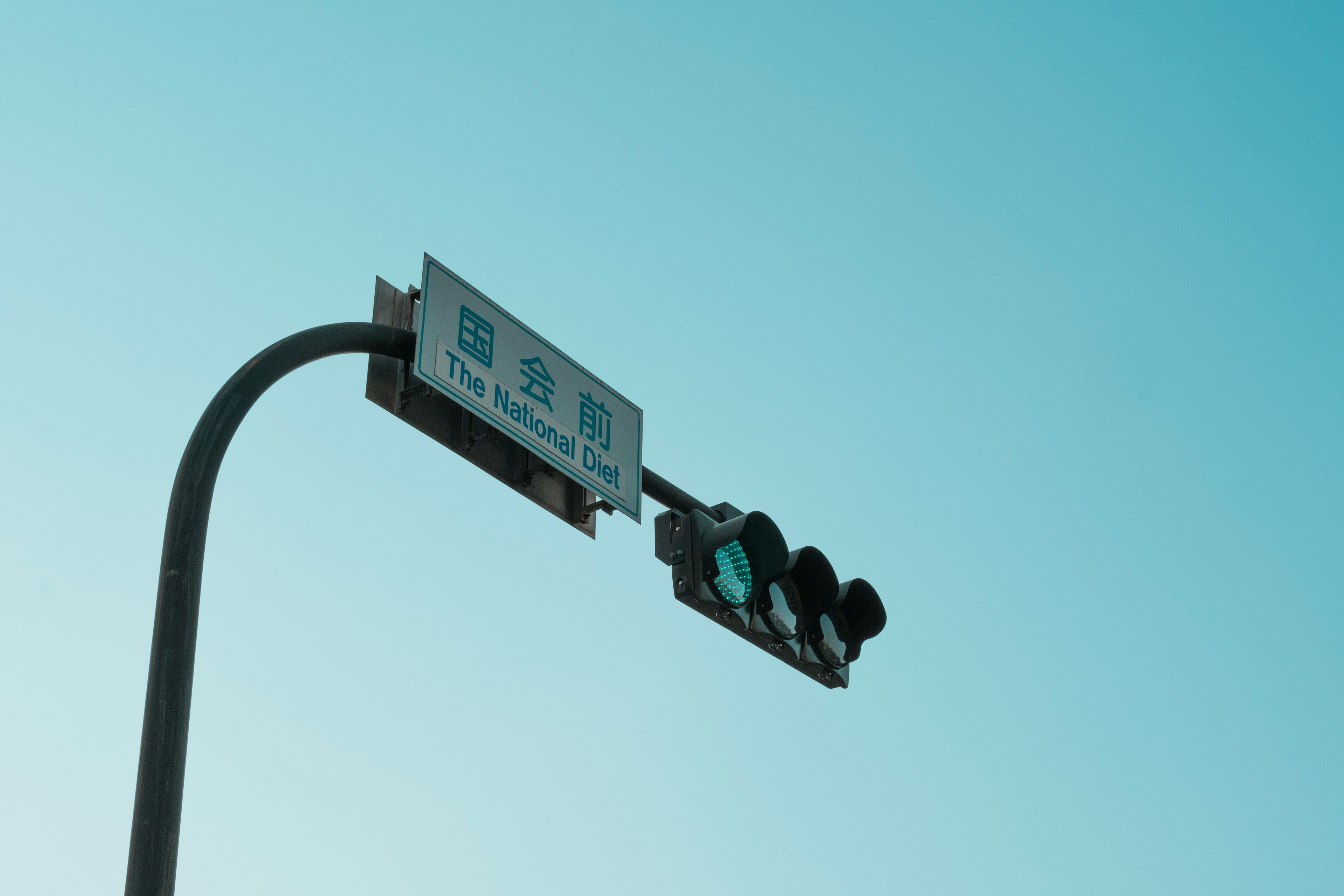 Traffic signal and sign under a clear blue sky