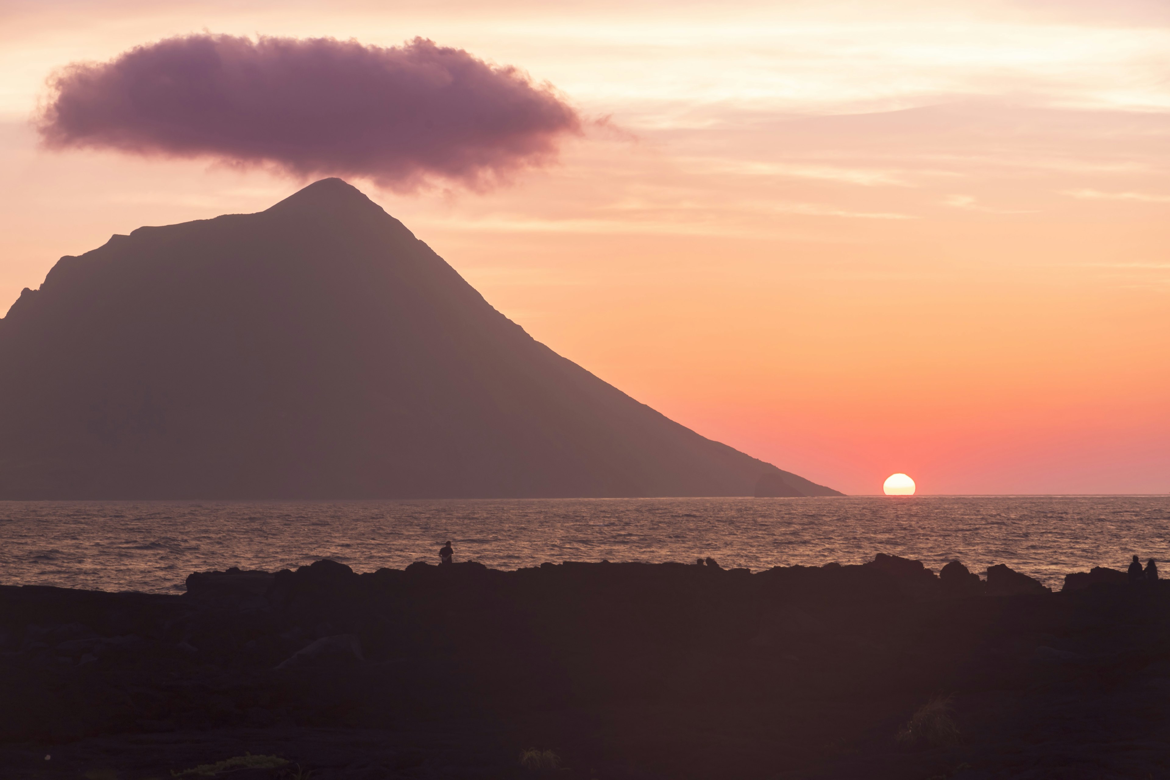 Tramonto sull'oceano con silhouette di montagna