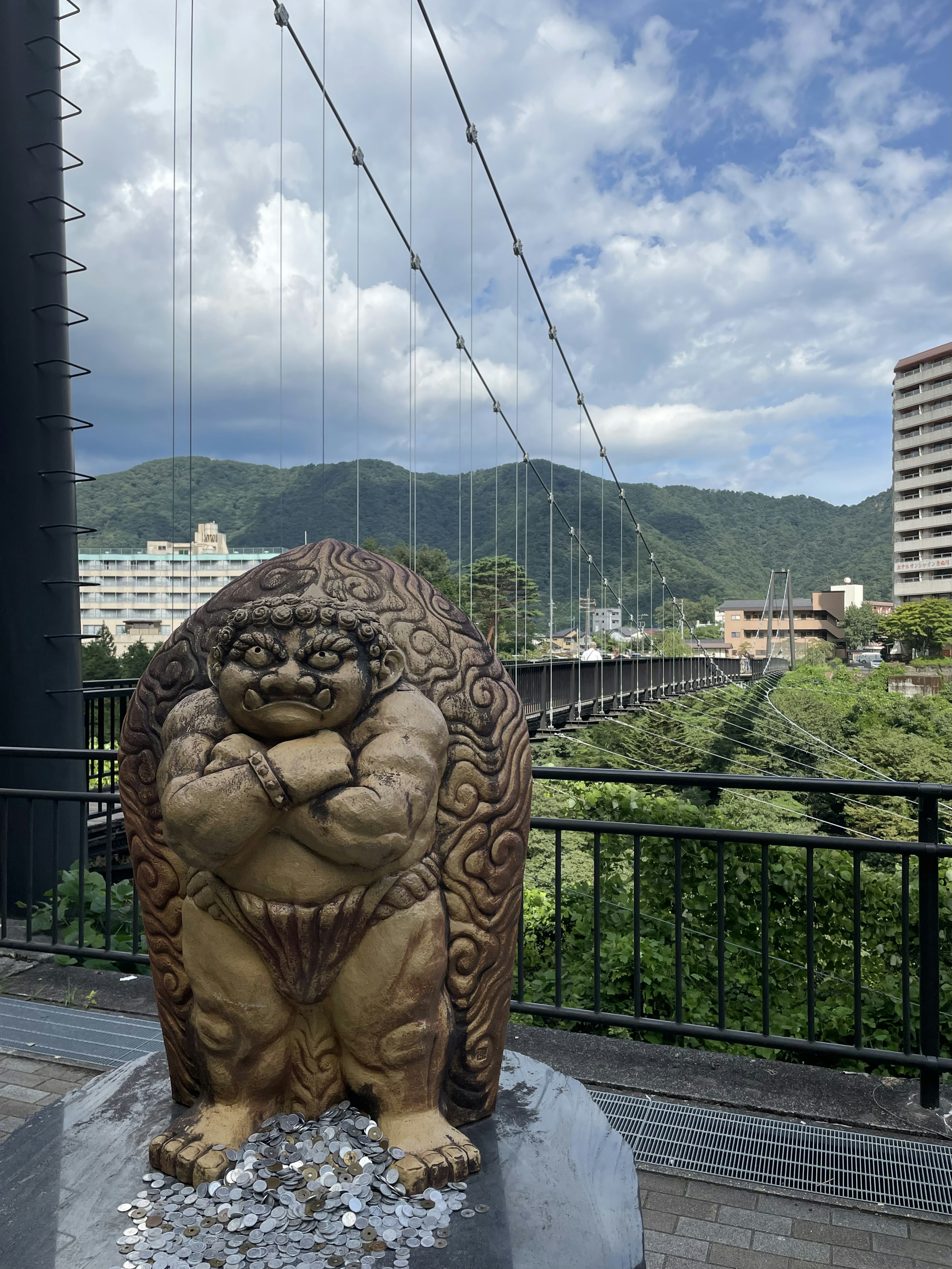 橋の近くにある大きな仏像と美しい山の風景