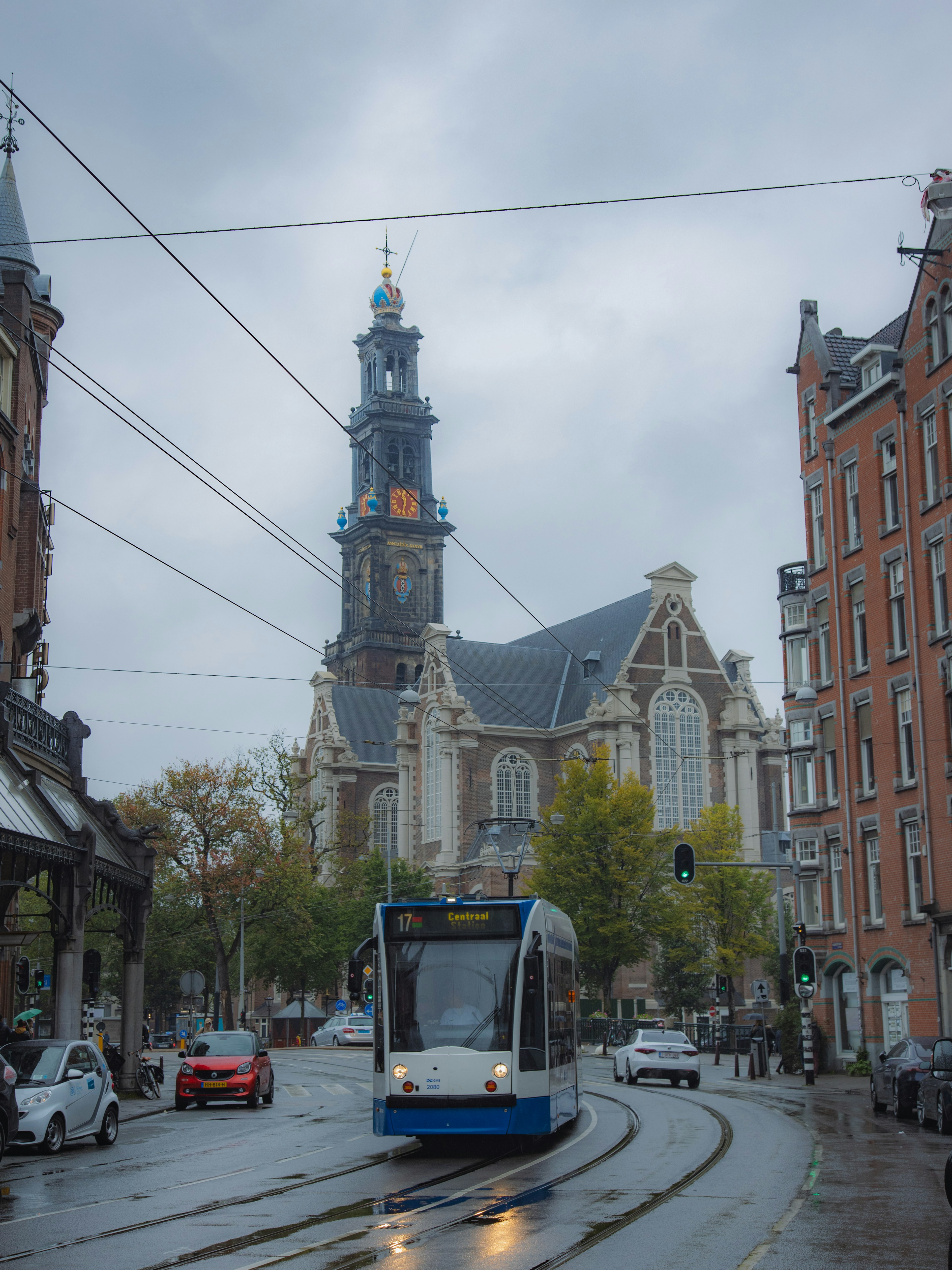 Tramway passant devant une église historique par un jour de pluie