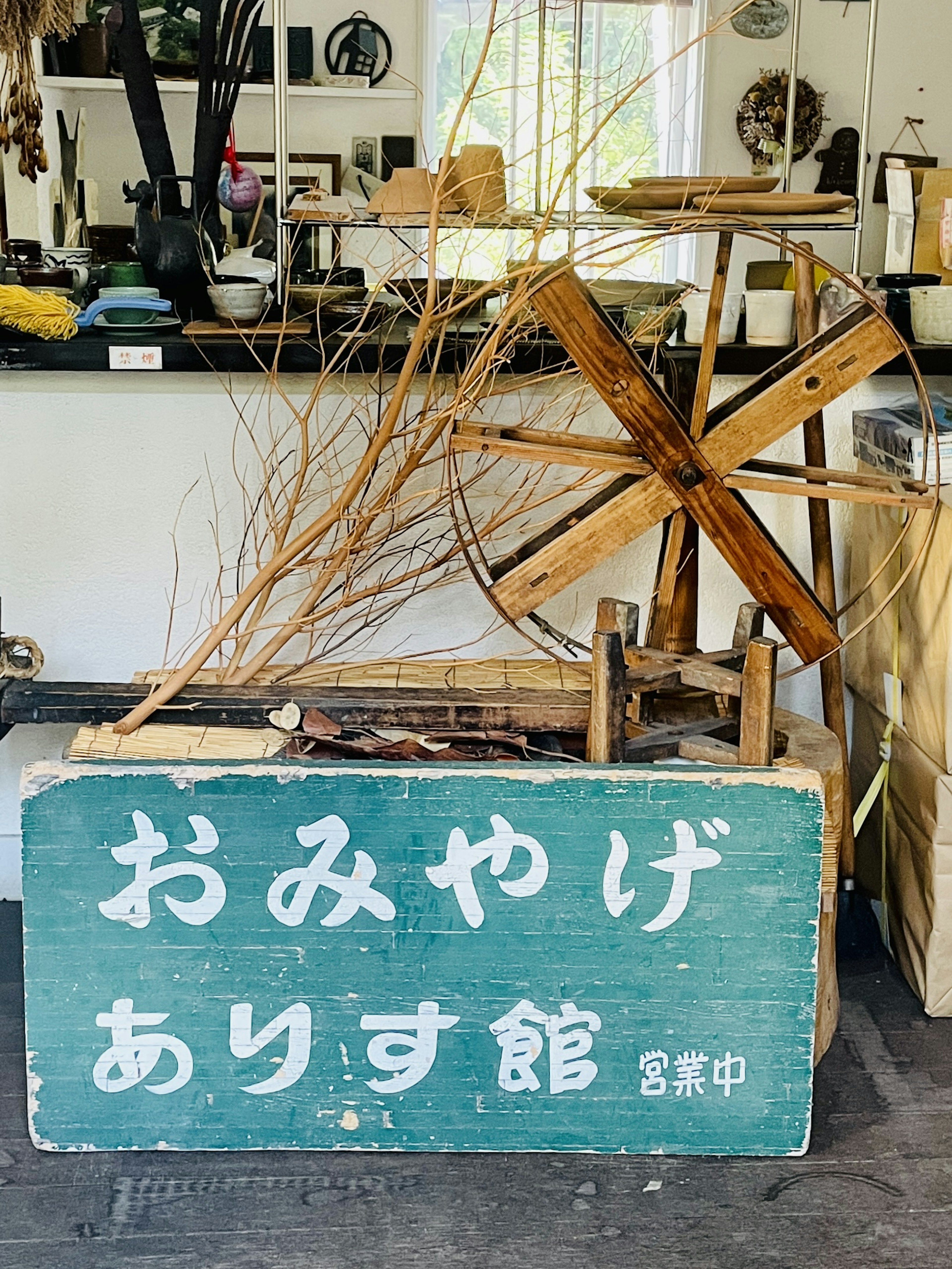 Rueda de madera y cartel en un espacio de exposición de artesanía