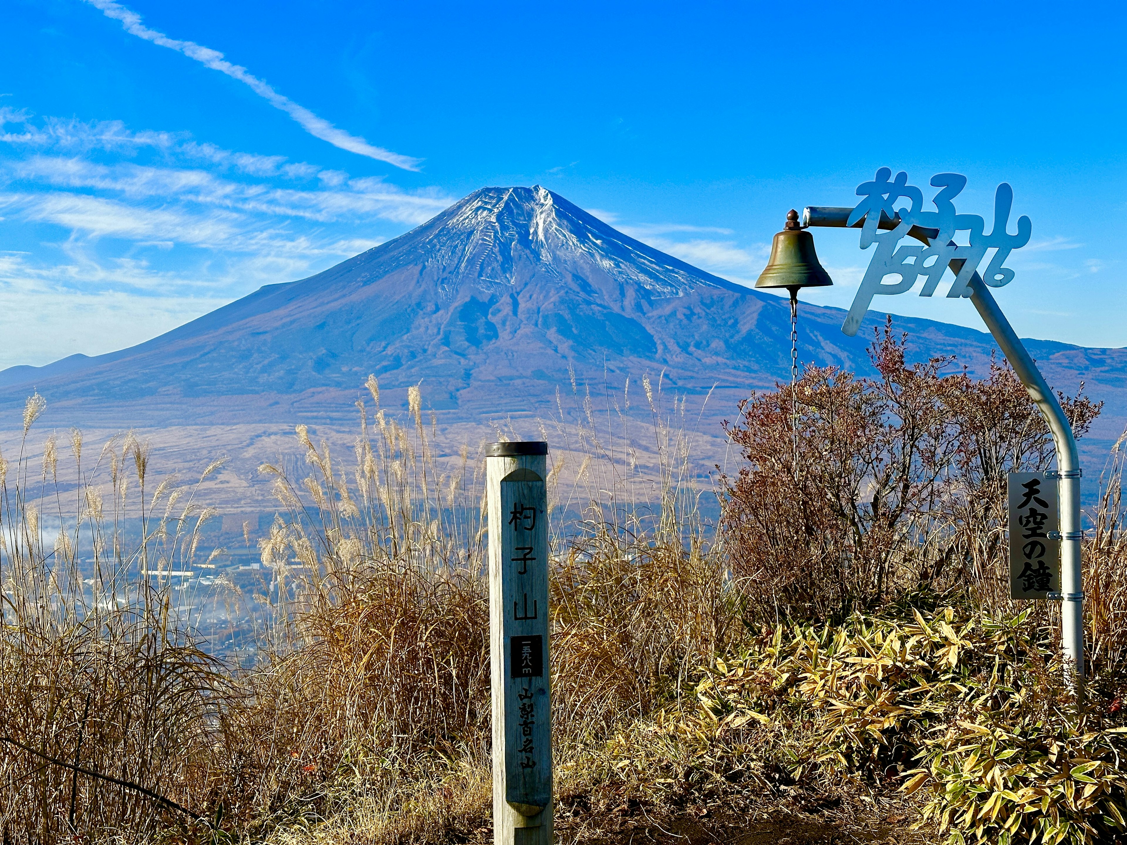 Vista panorámica del monte Fuji con una campana bajo un cielo azul claro