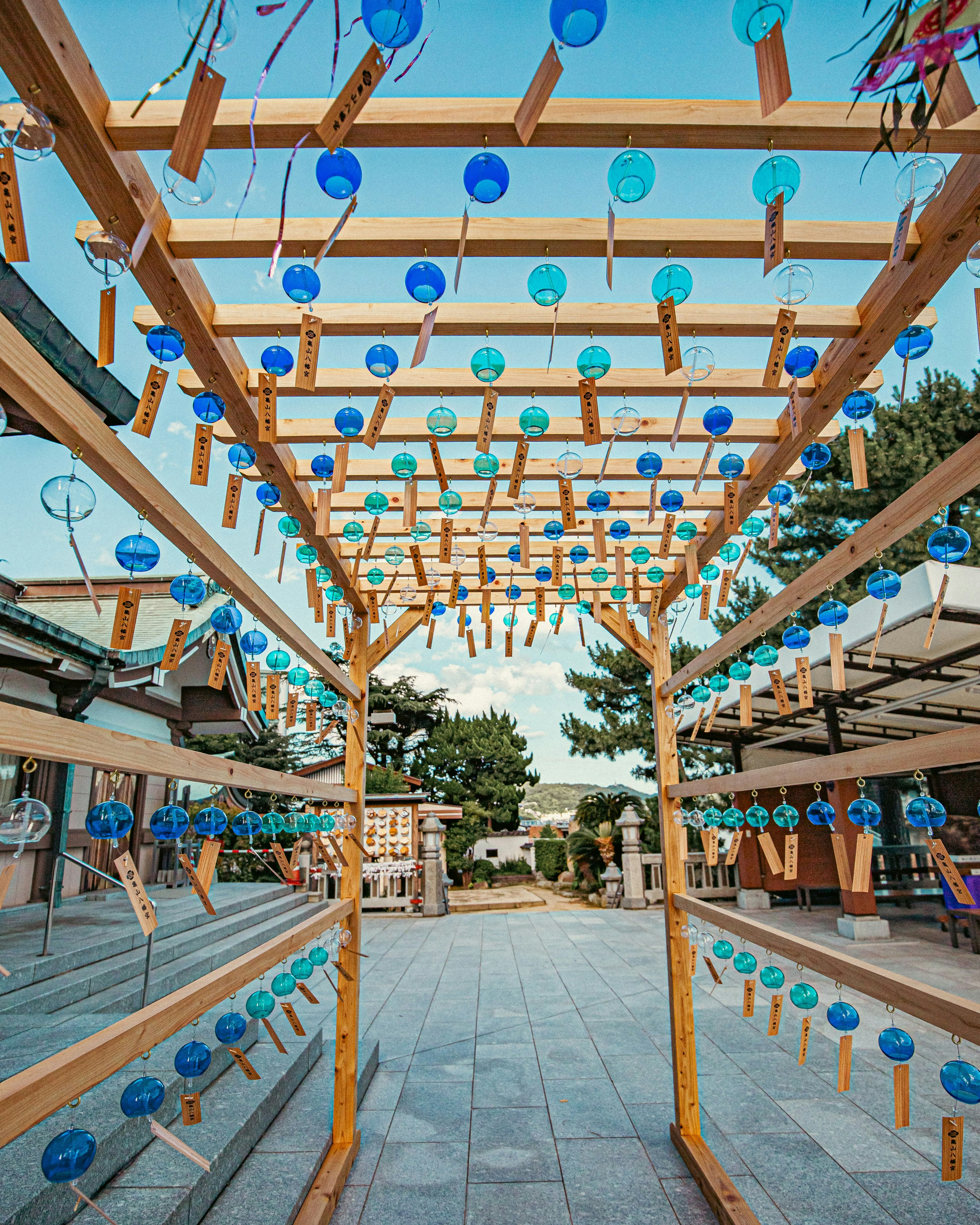 Arco di legno decorato con campane a vento blu e trasparenti