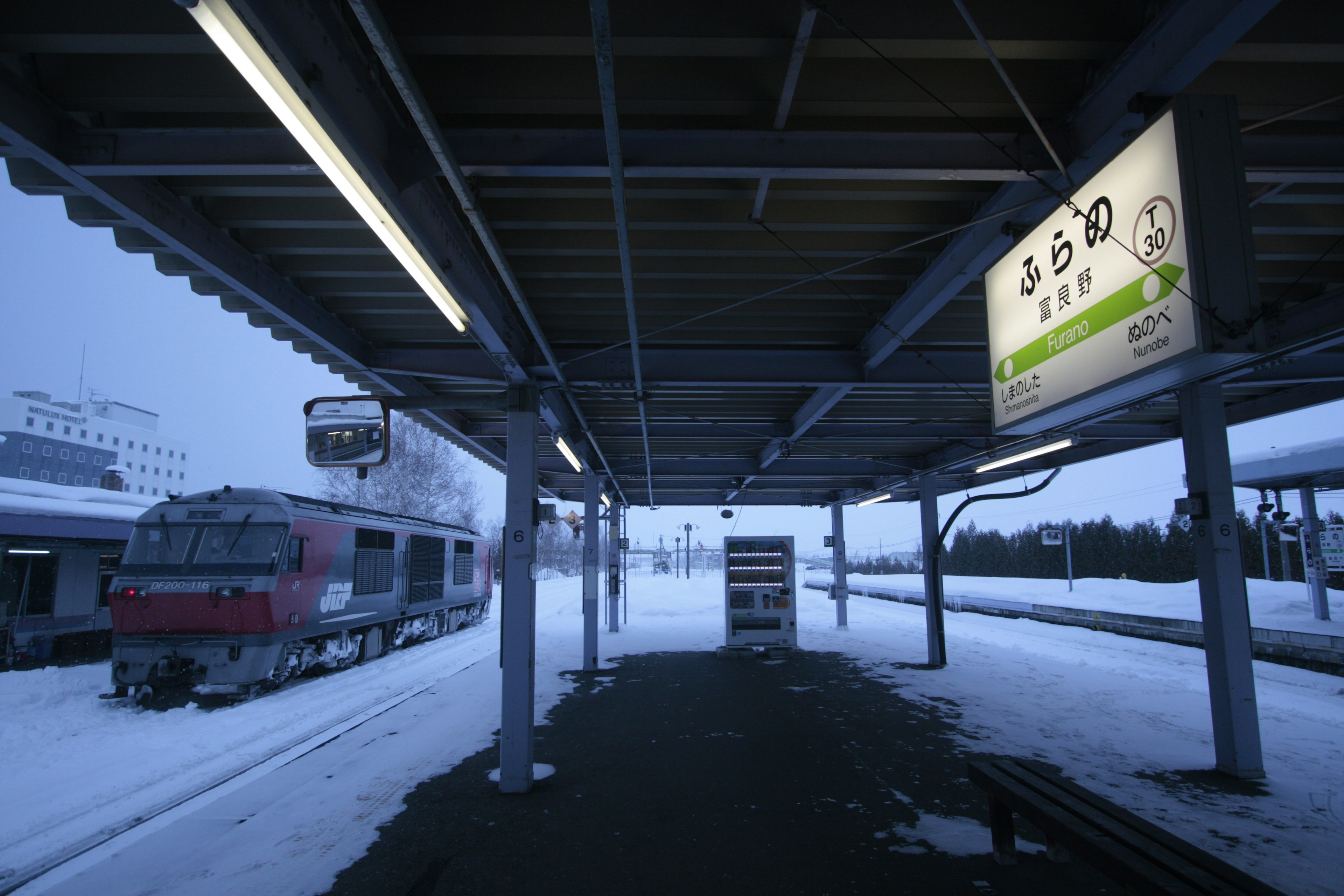 雪に覆われた駅のプラットフォームと電車の風景