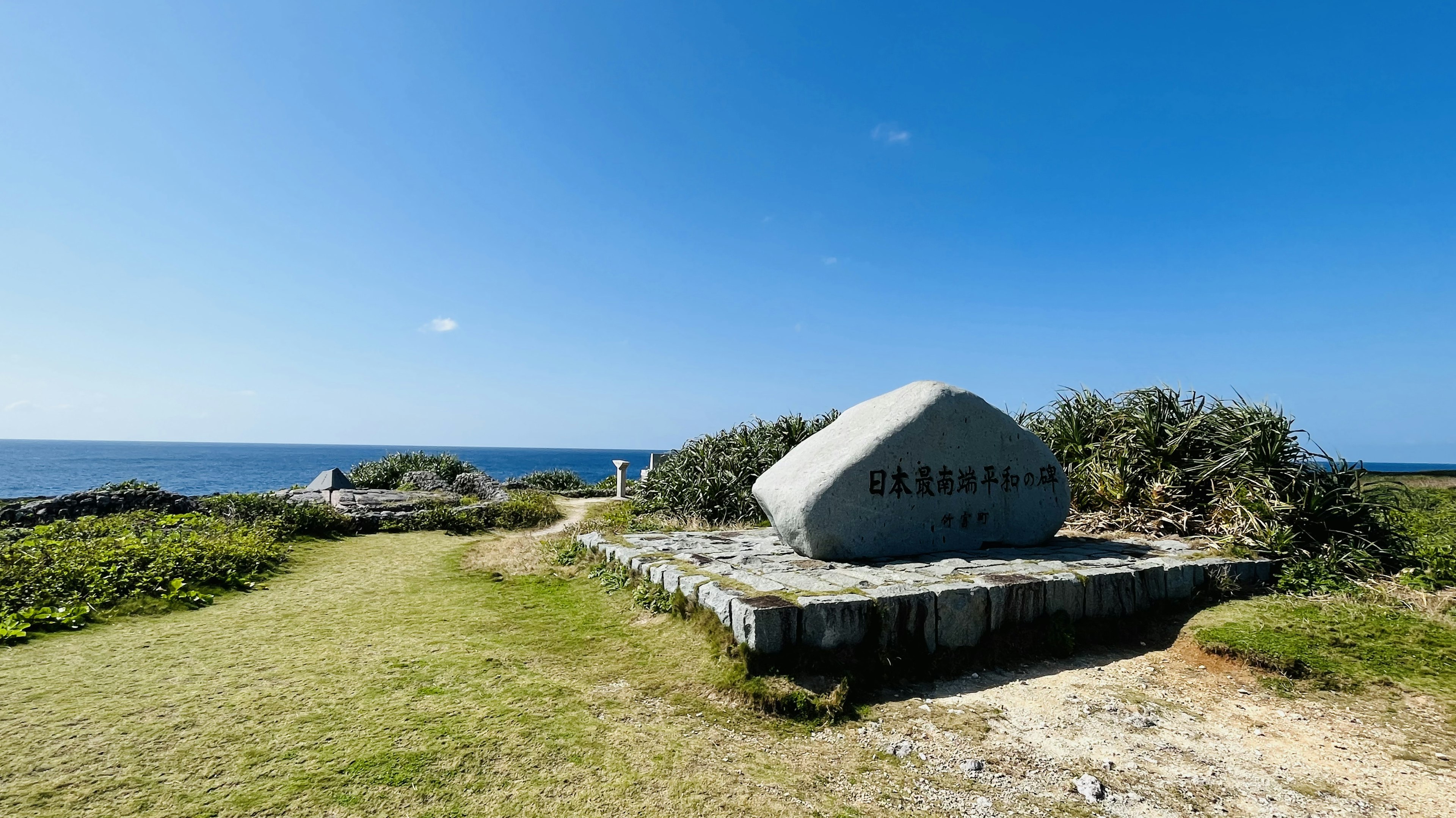 Großes Steindenkmal in der Nähe des Meeres mit grünem Gras