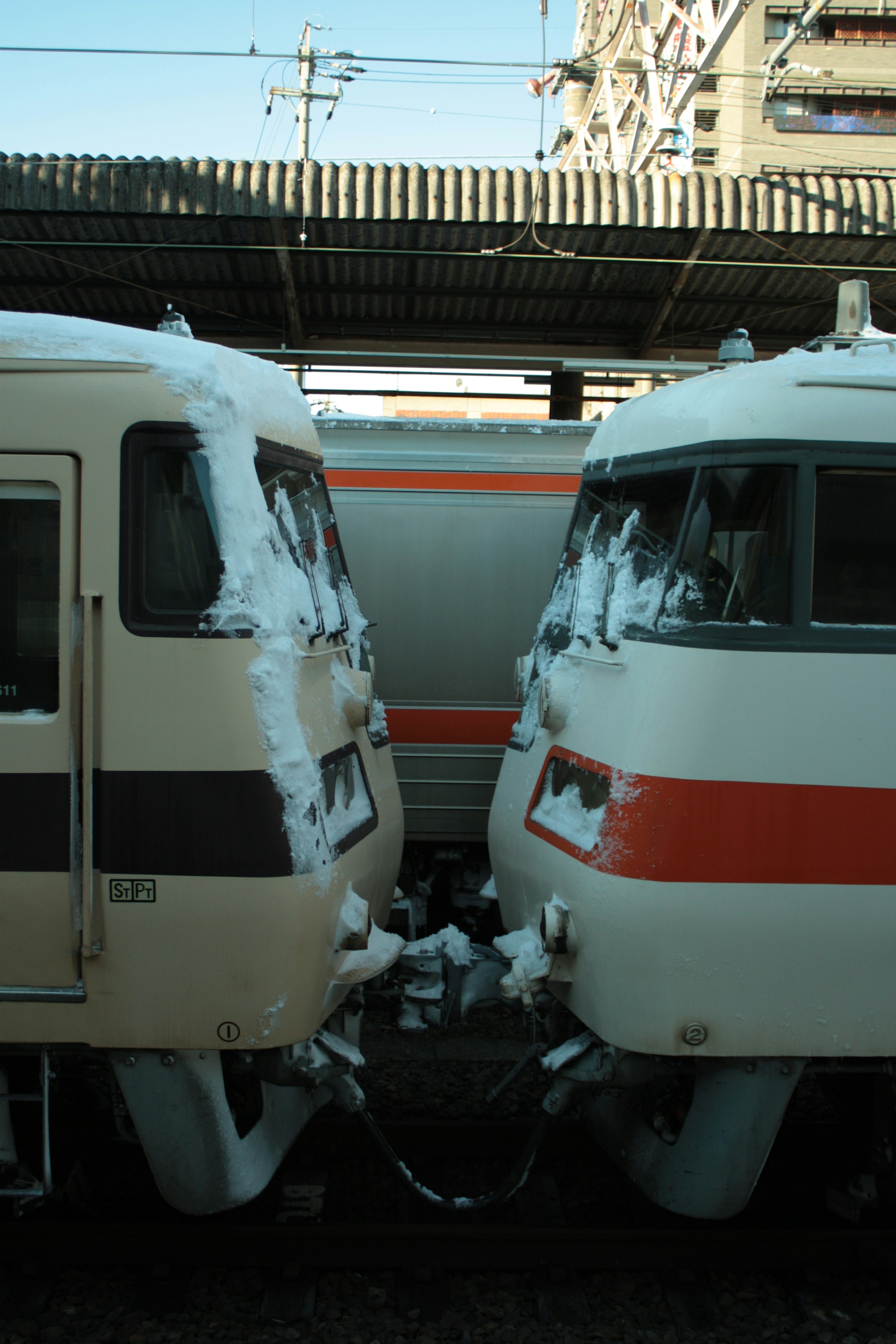 雪に覆われた二つの列車が接近している駅の風景