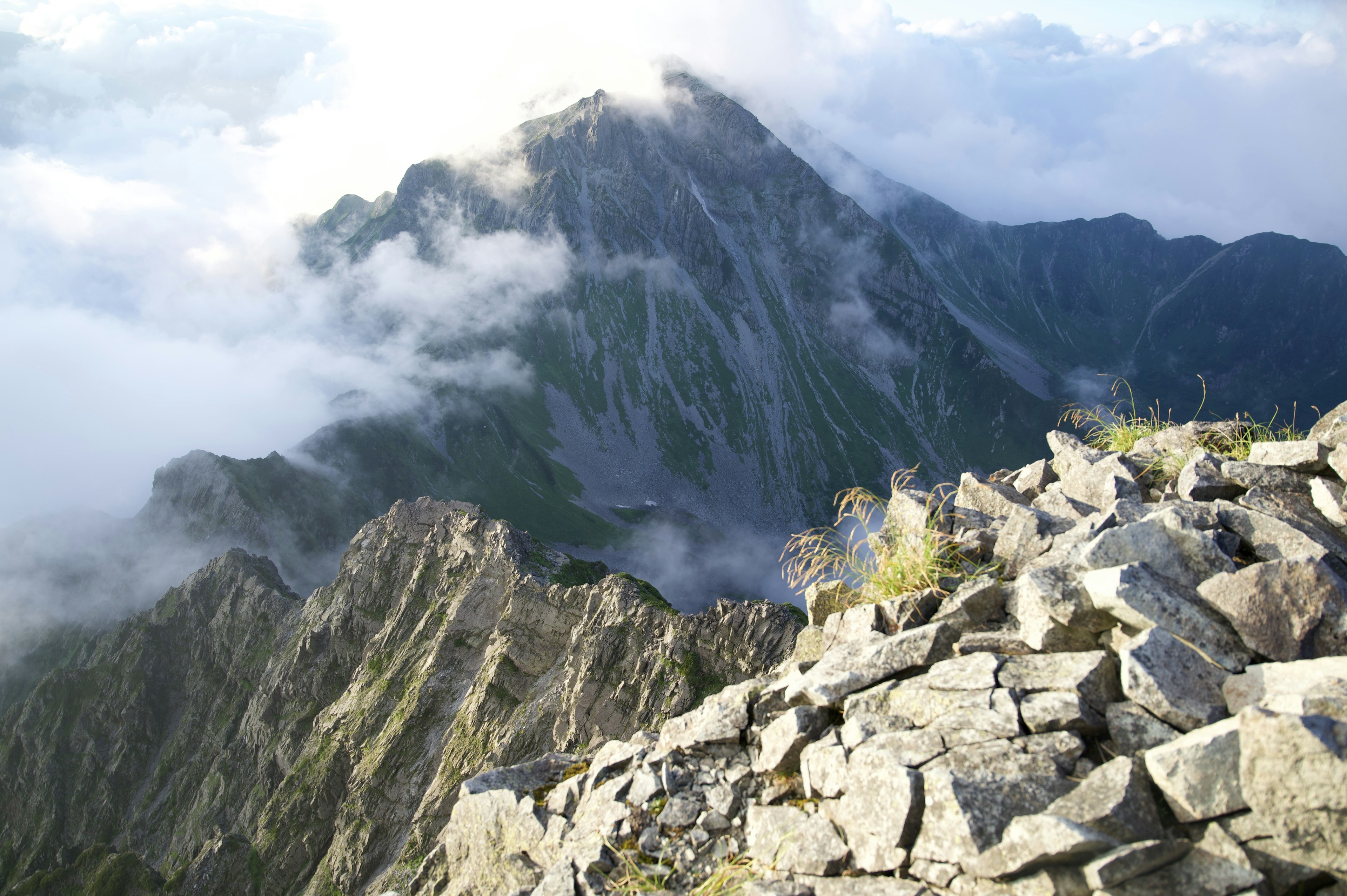 雲霧繚繞的山景和岩石前景