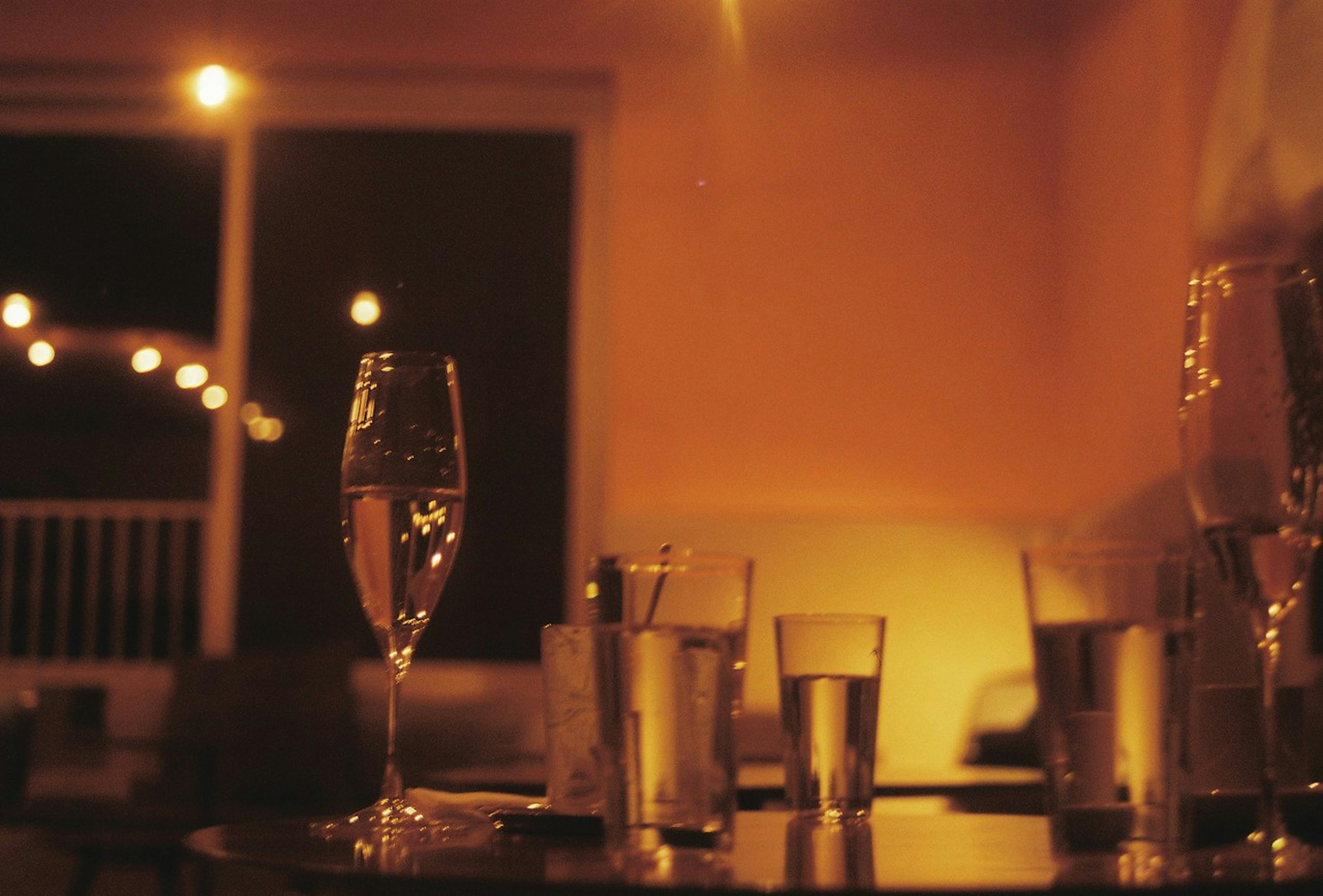 Table with cocktail glasses and water cups in a dimly lit bar