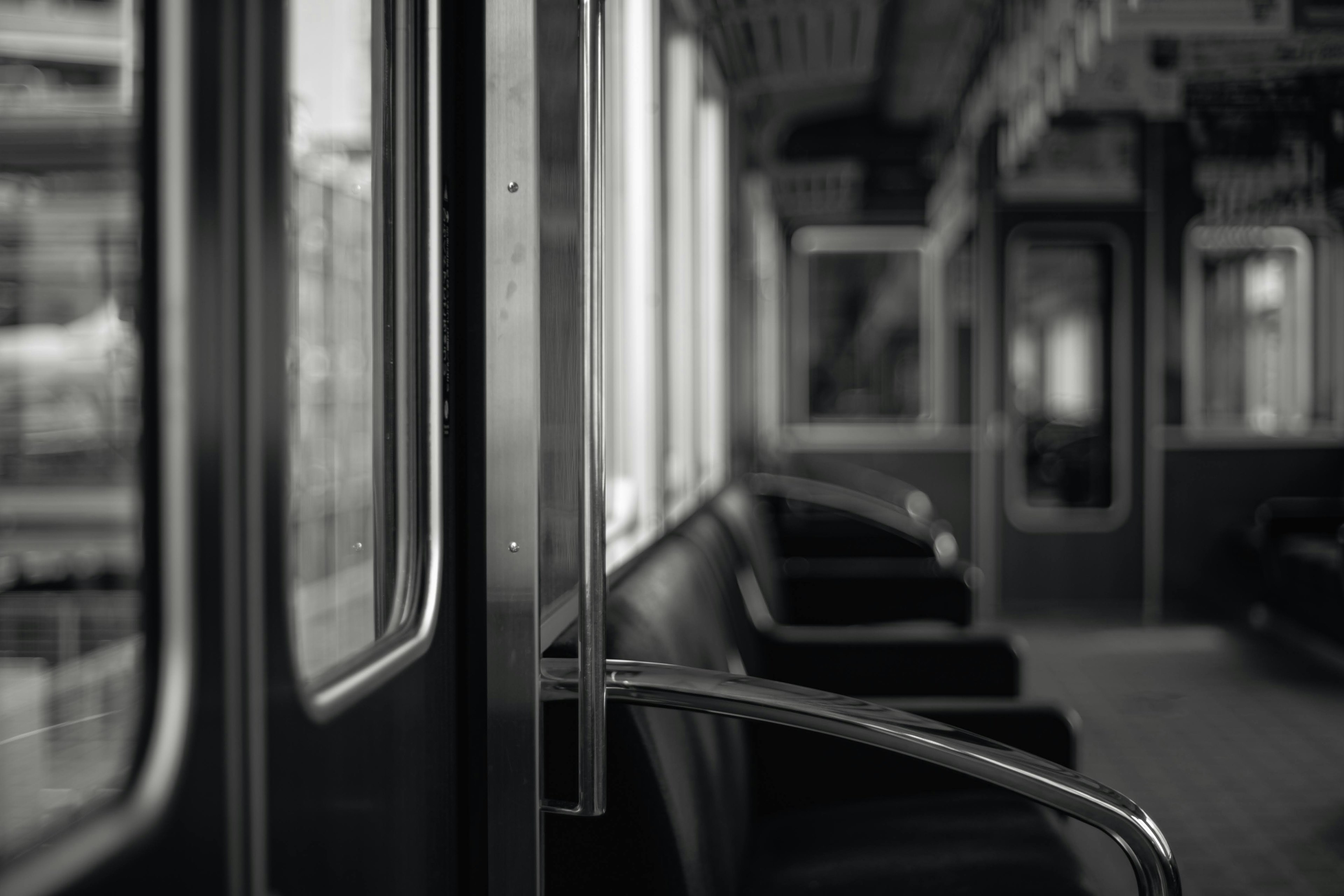 Interior of a monochrome train carriage with seats and door details