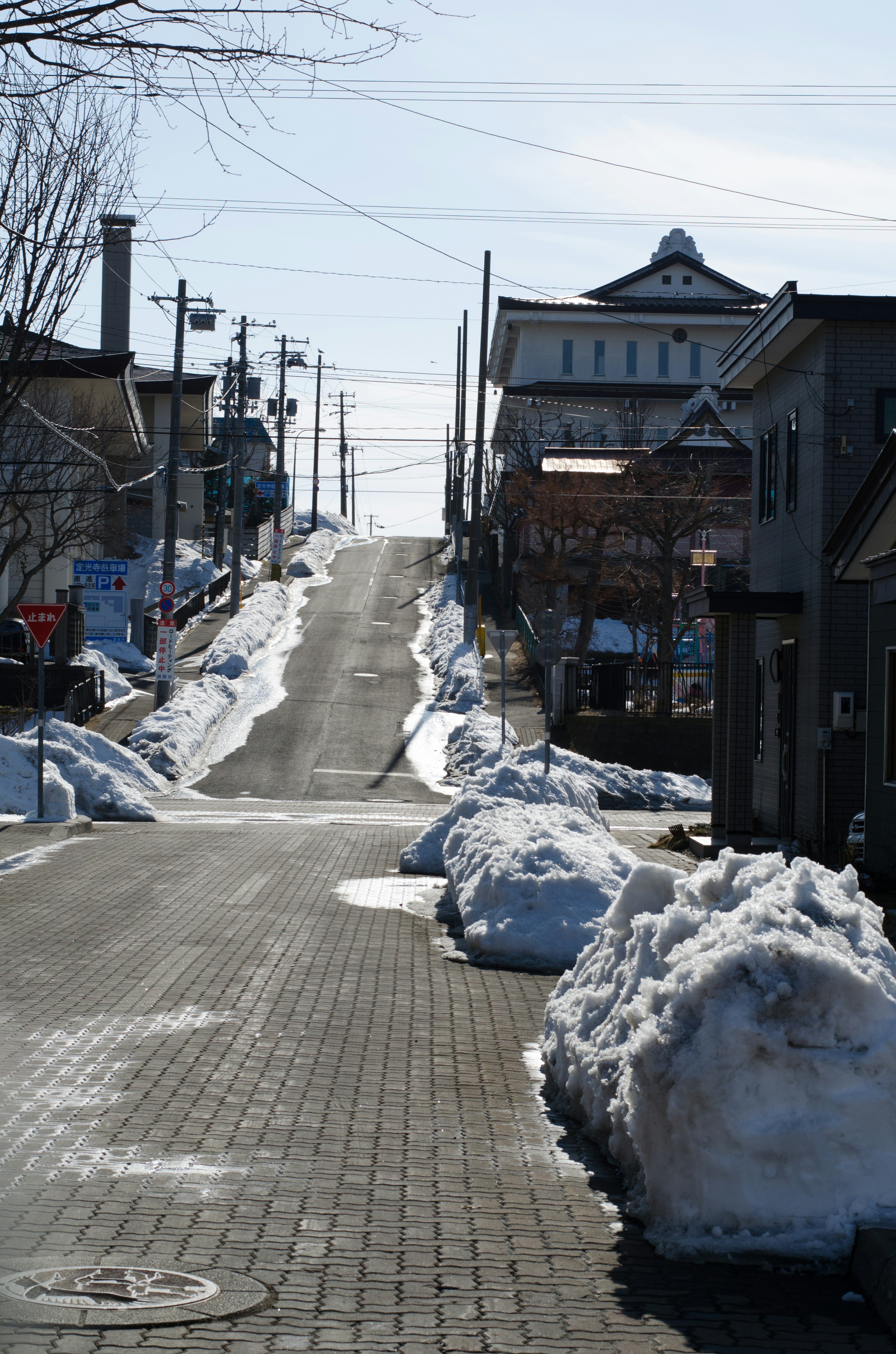 Calle en pendiente cubierta de nieve con paisaje urbano tranquilo