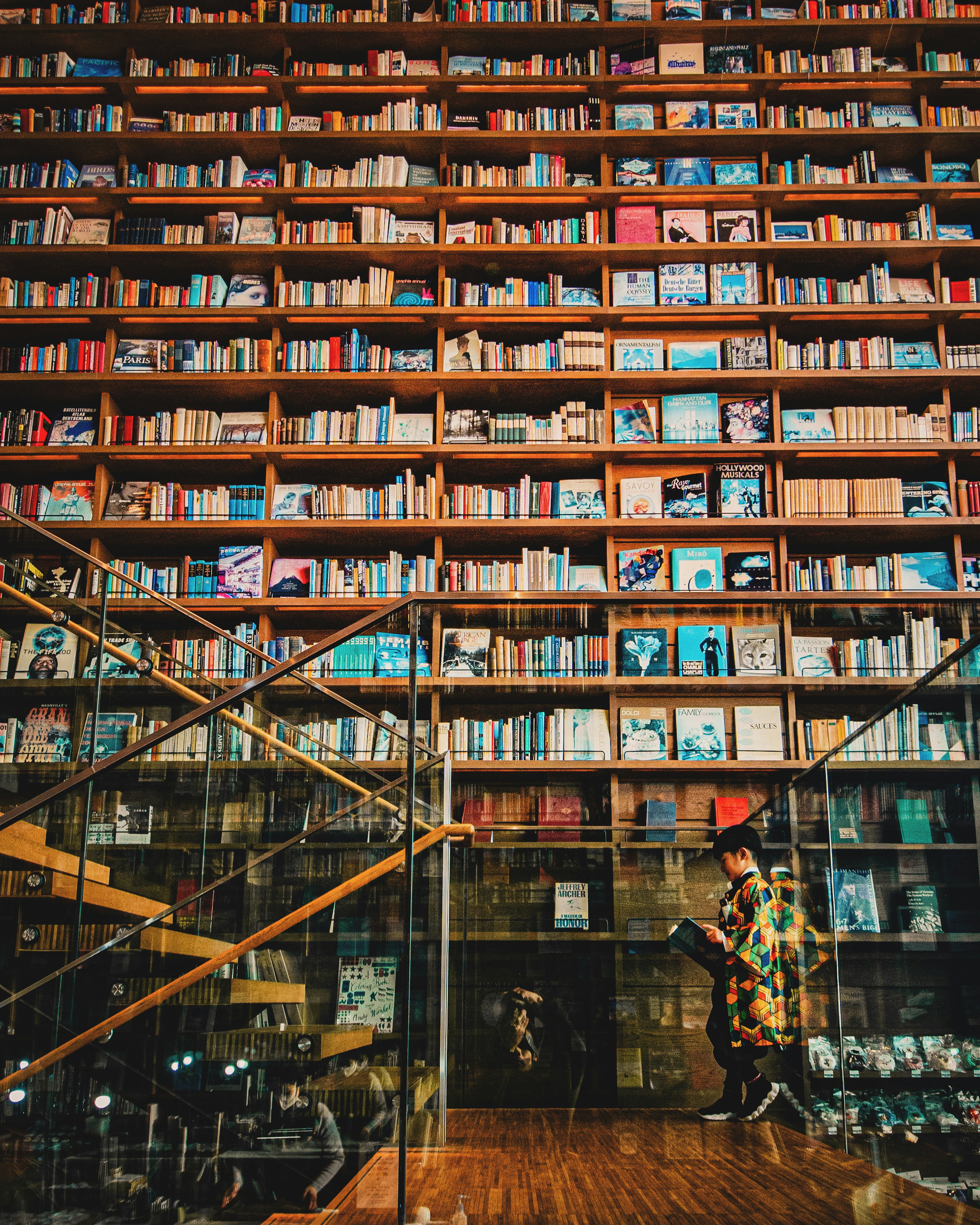 Personne se tenant dans une bibliothèque avec une magnifique étagère