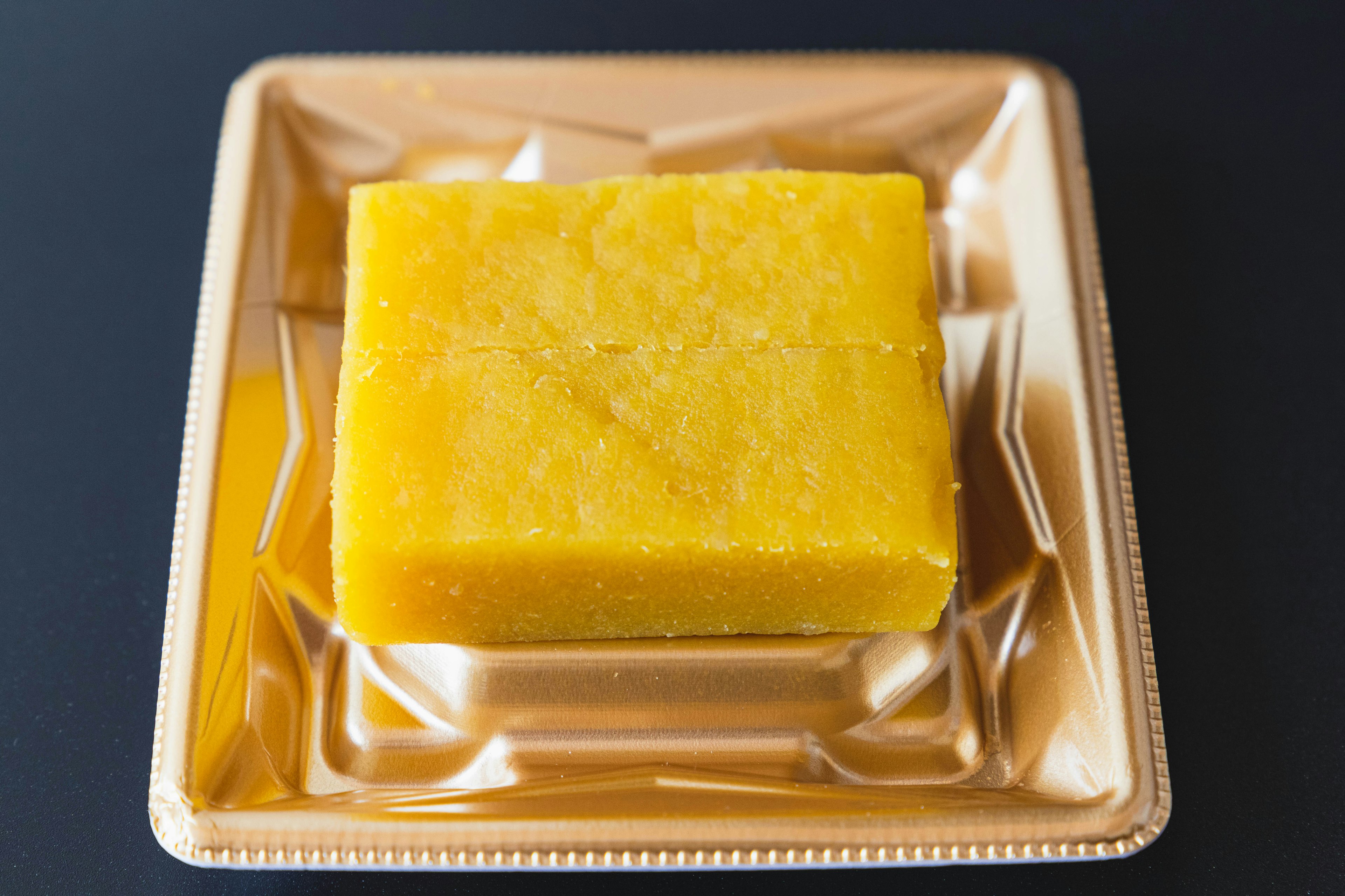 Dessert en bloc jaune sur une assiette dorée