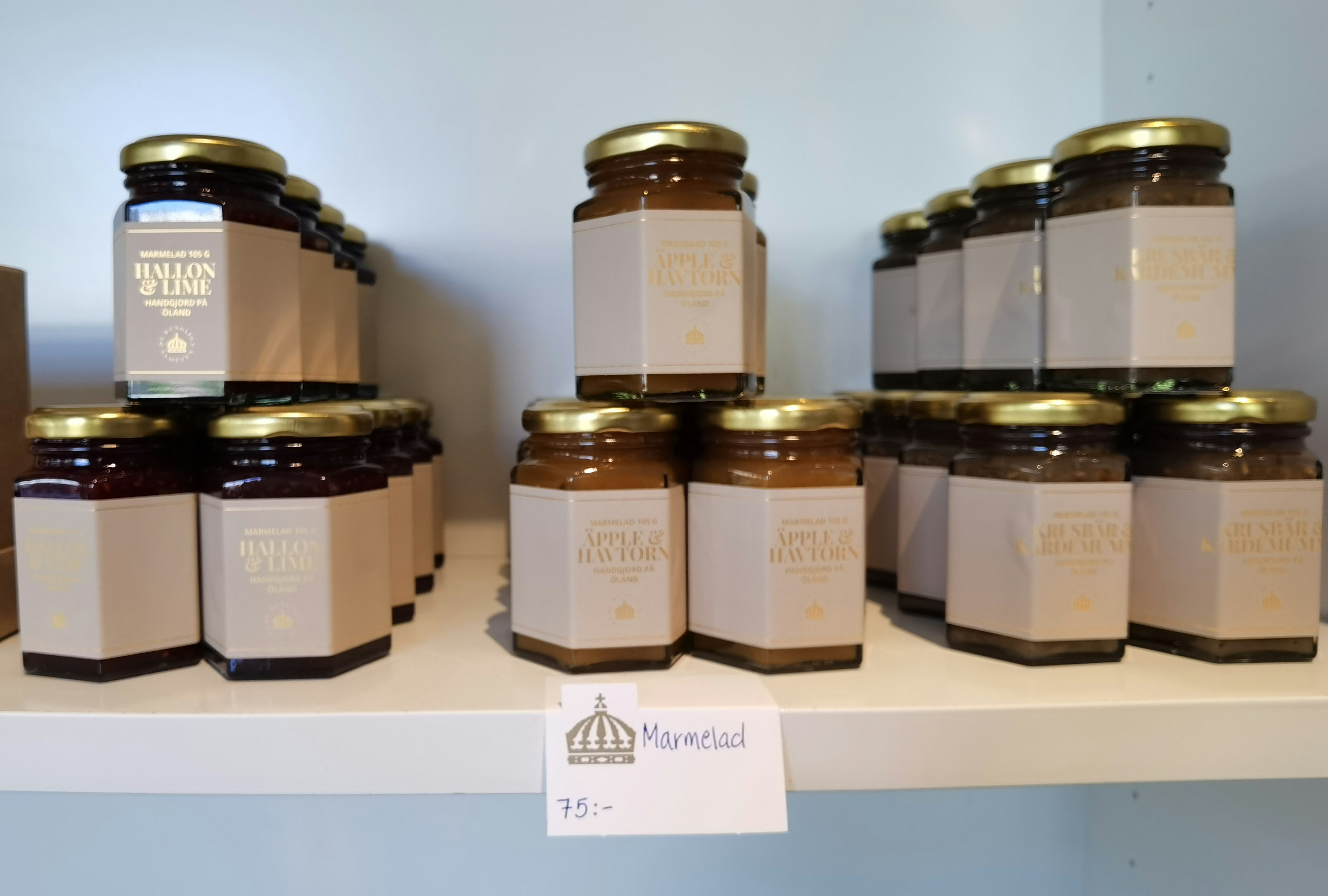 Image featuring jars of jam arranged on a shelf with distinctive labels