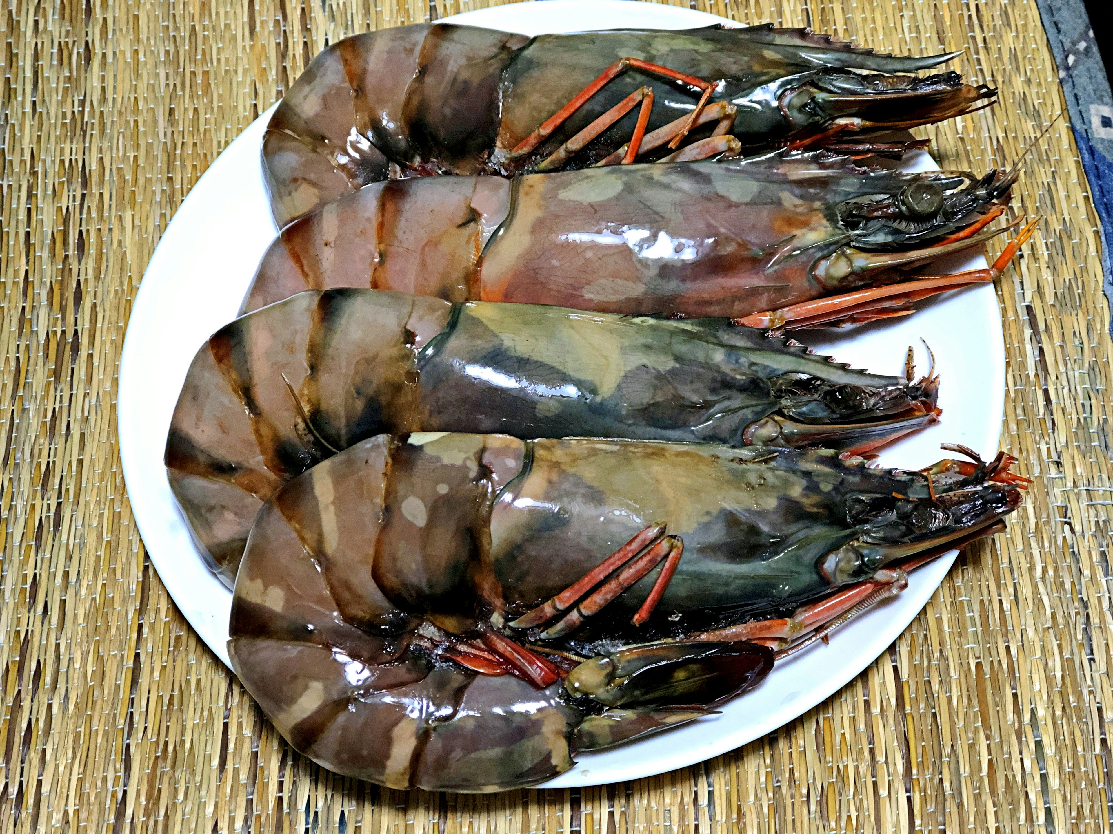 Camarones grandes dispuestos en un plato blanco