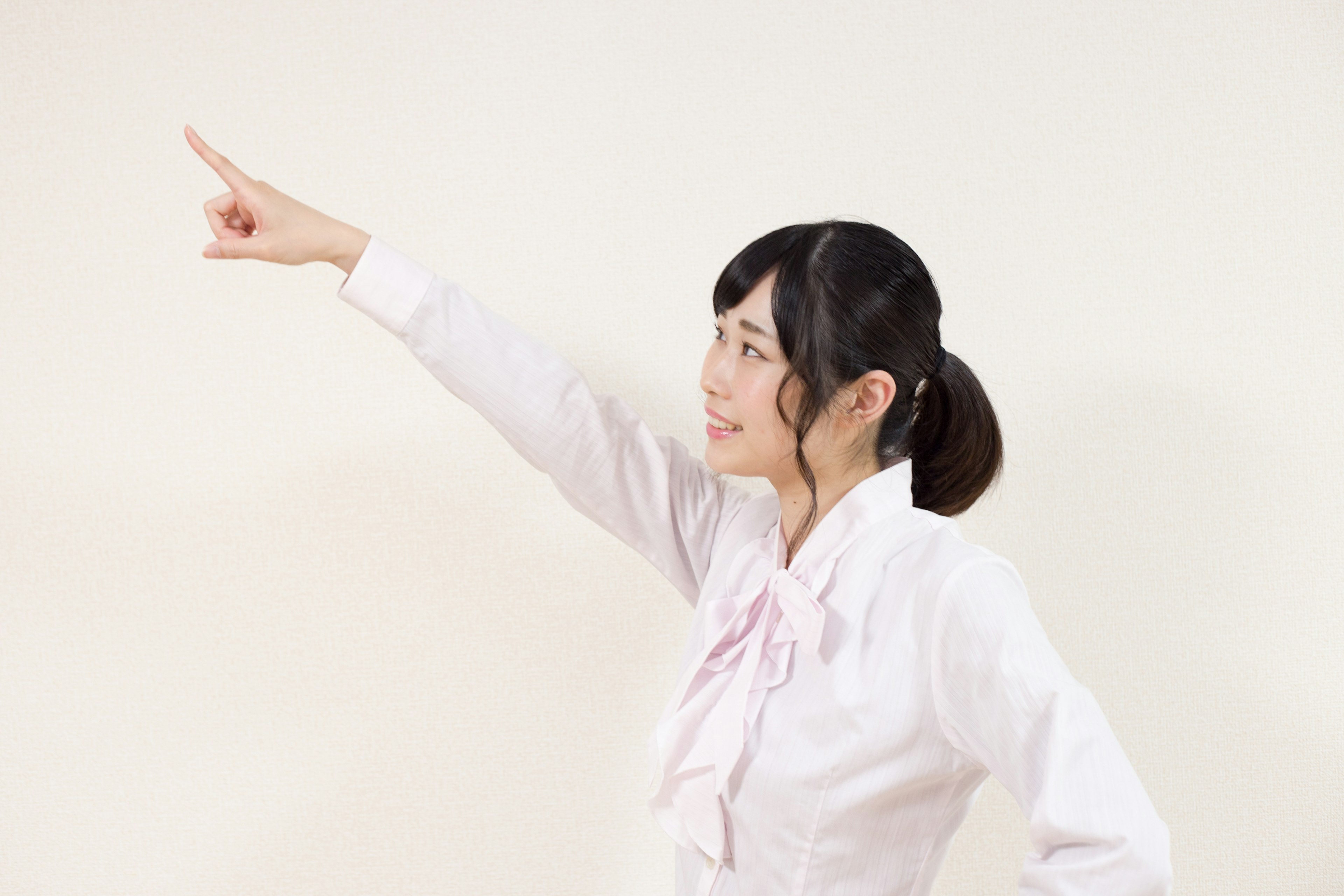 Woman in a white shirt pointing with her right hand