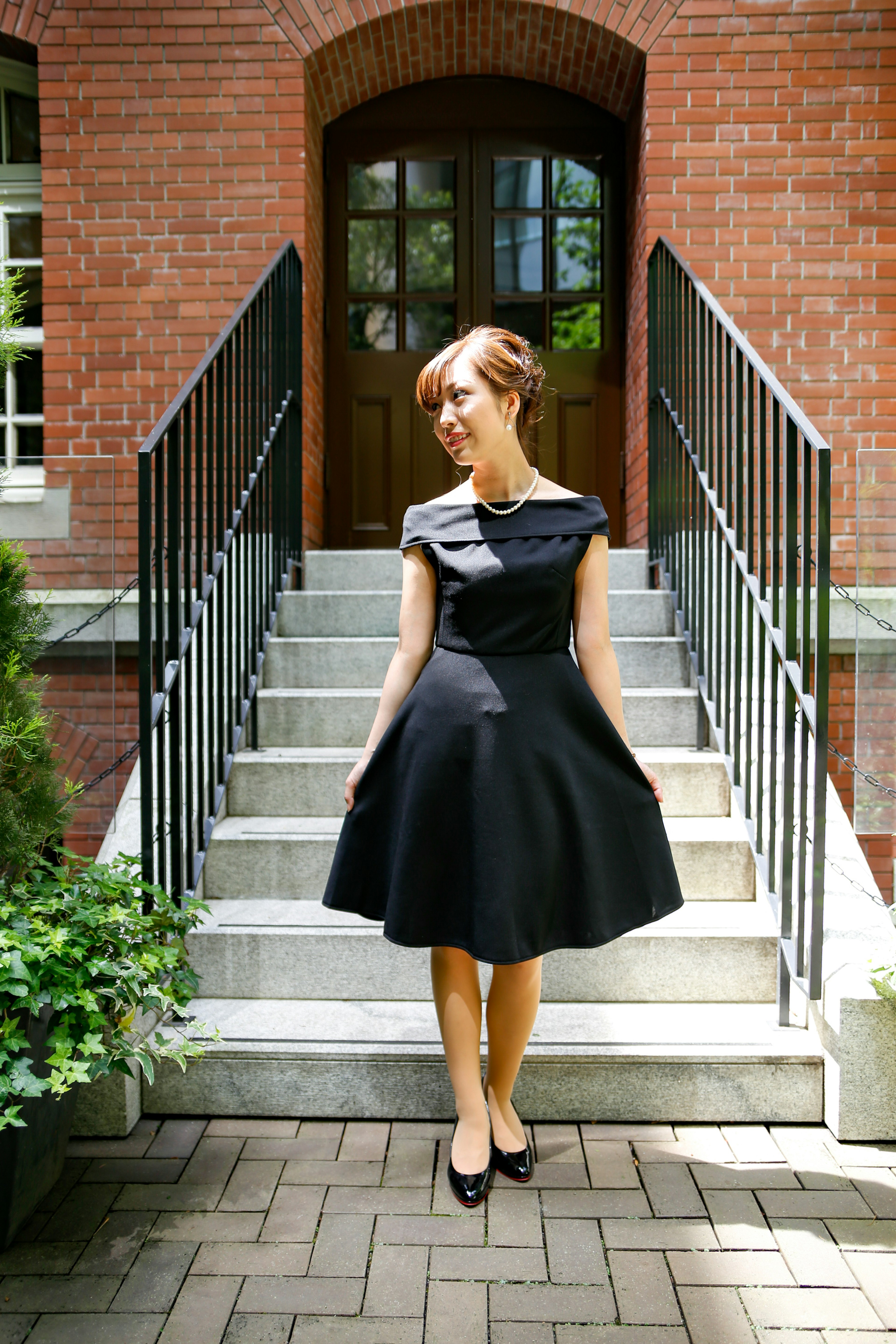 A woman in a black dress standing on a staircase