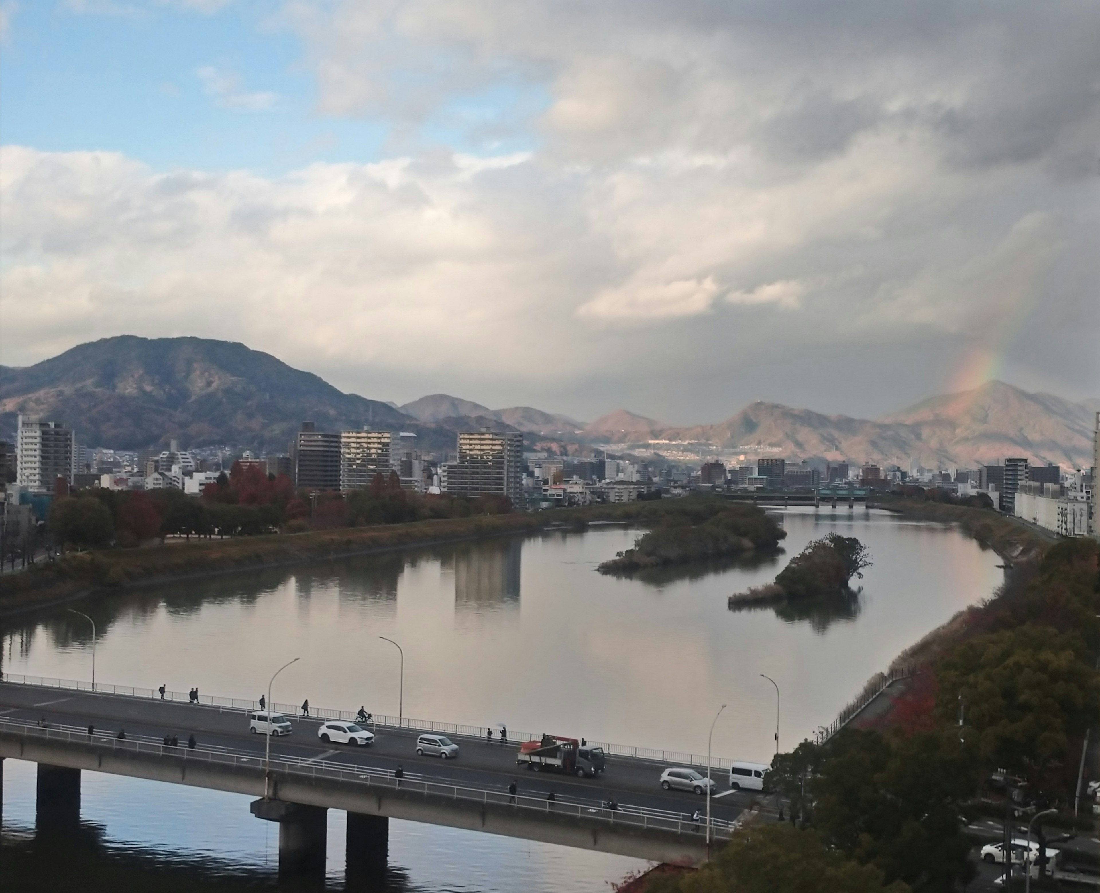 Paisaje urbano con un río y montañas con un arcoíris