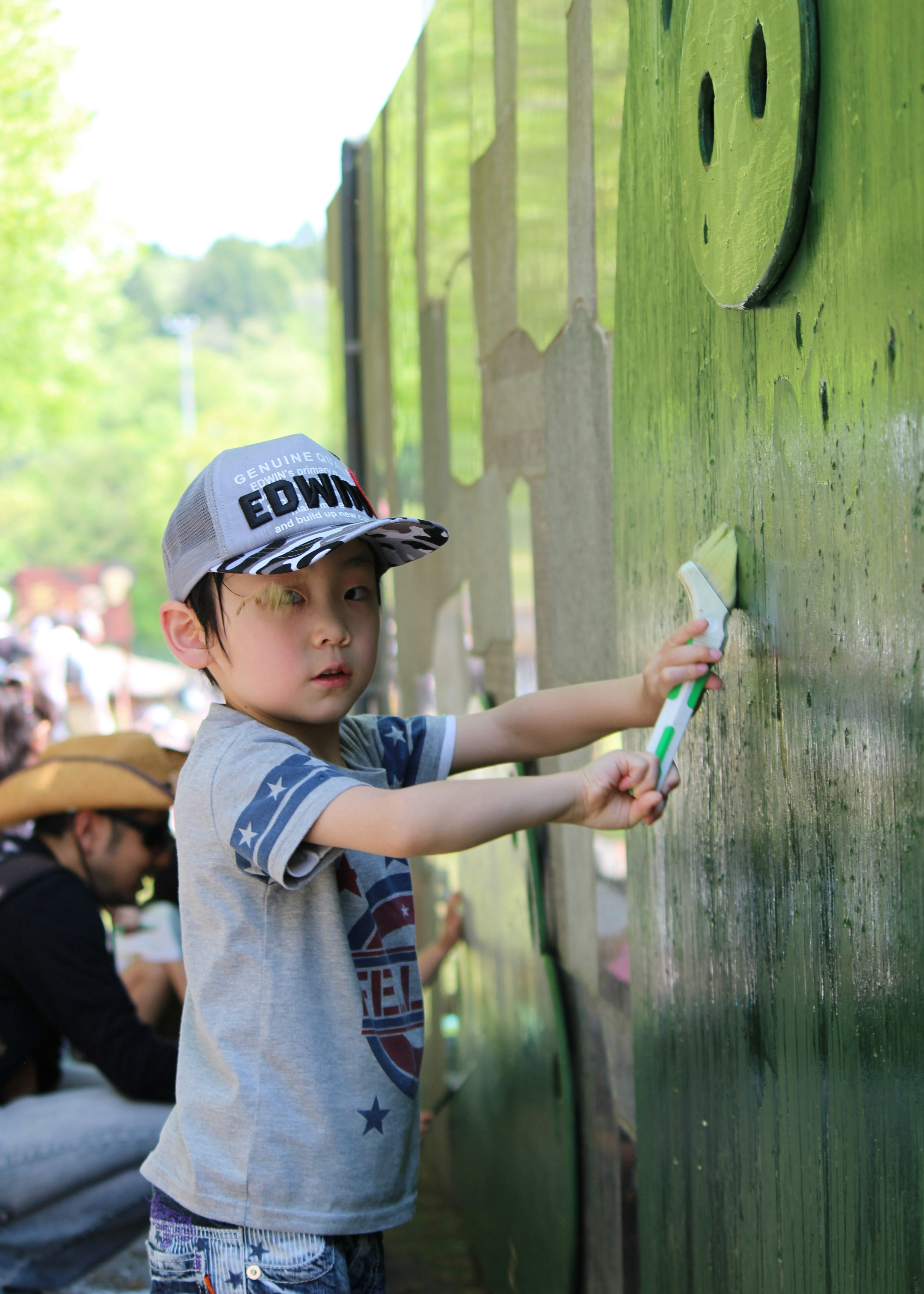 Un niño pintando una pared verde