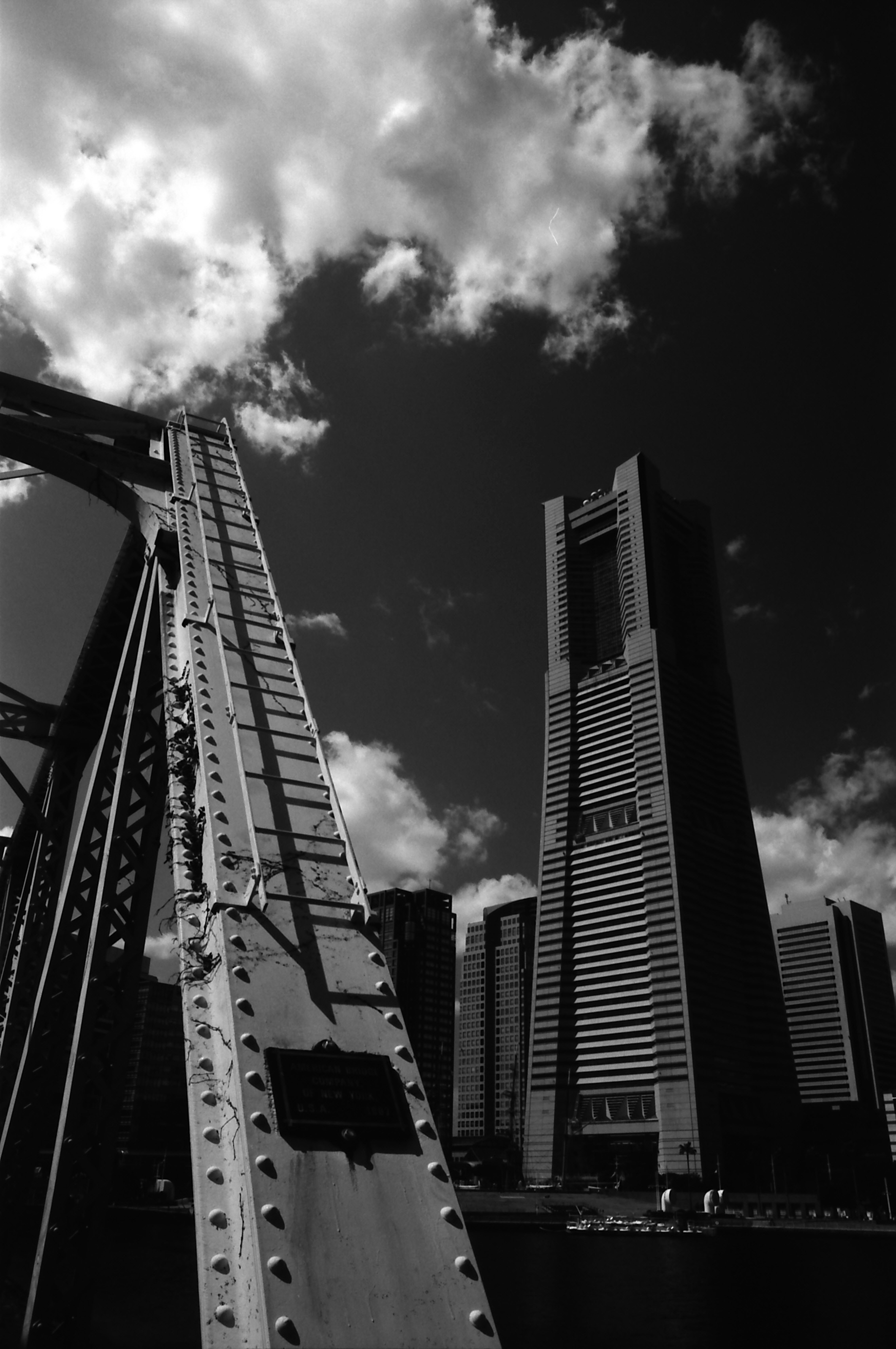 Foto in bianco e nero di grattacieli di Yokohama e ponte in metallo