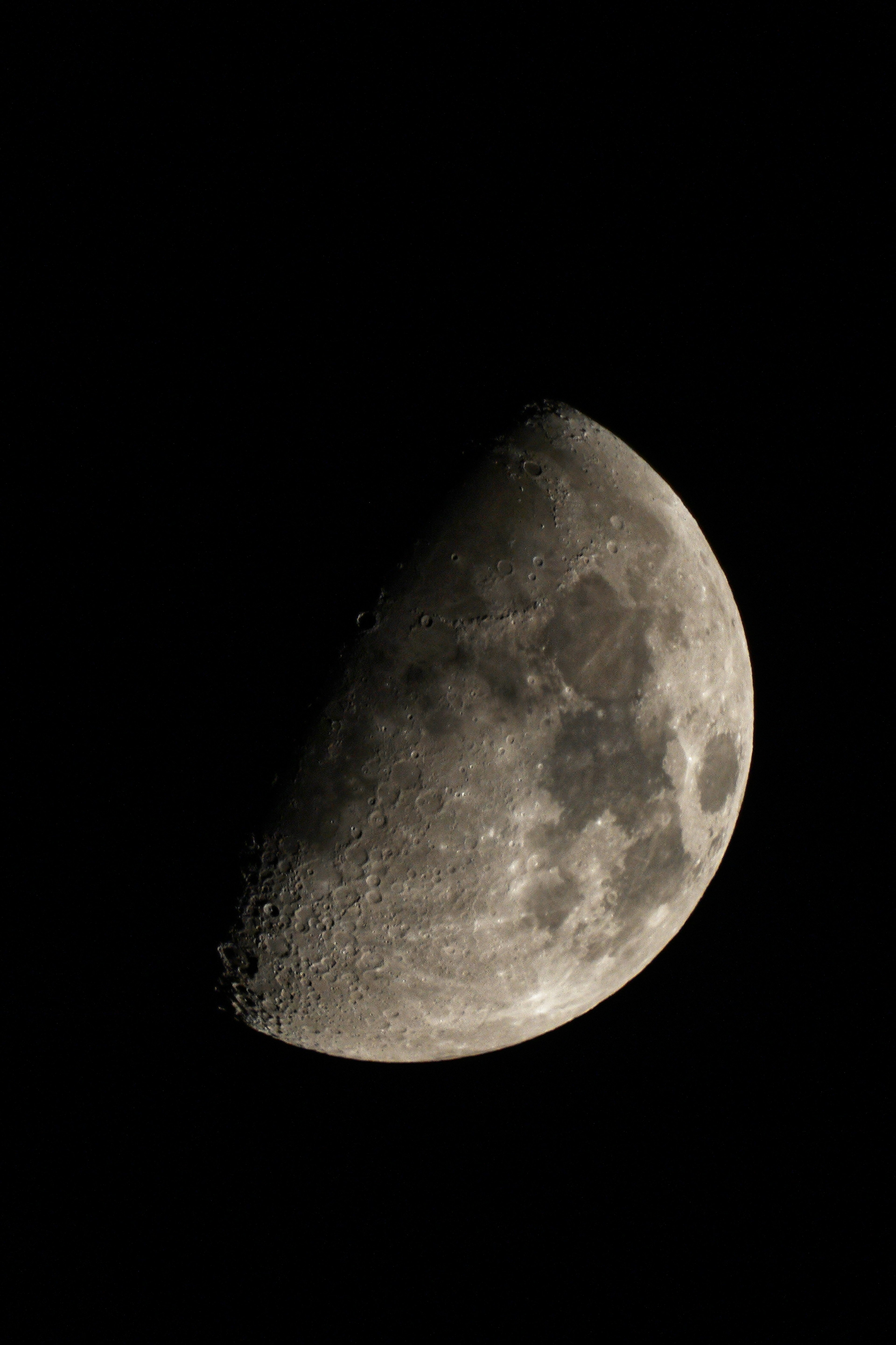 Immagine di una luna mezza brillante con crateri visibili