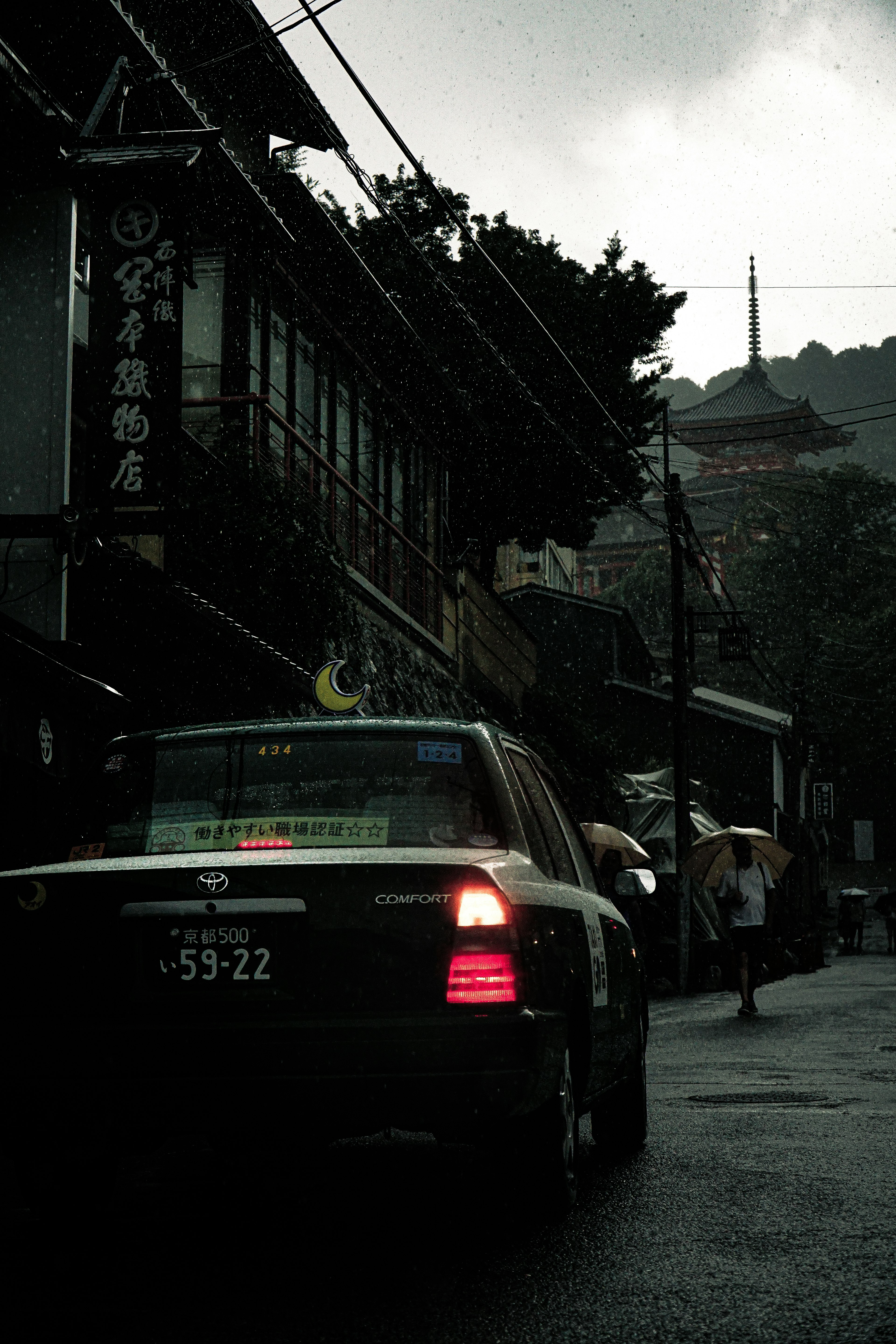 Taxi sous la pluie avec des bâtiments anciens et une tour au loin