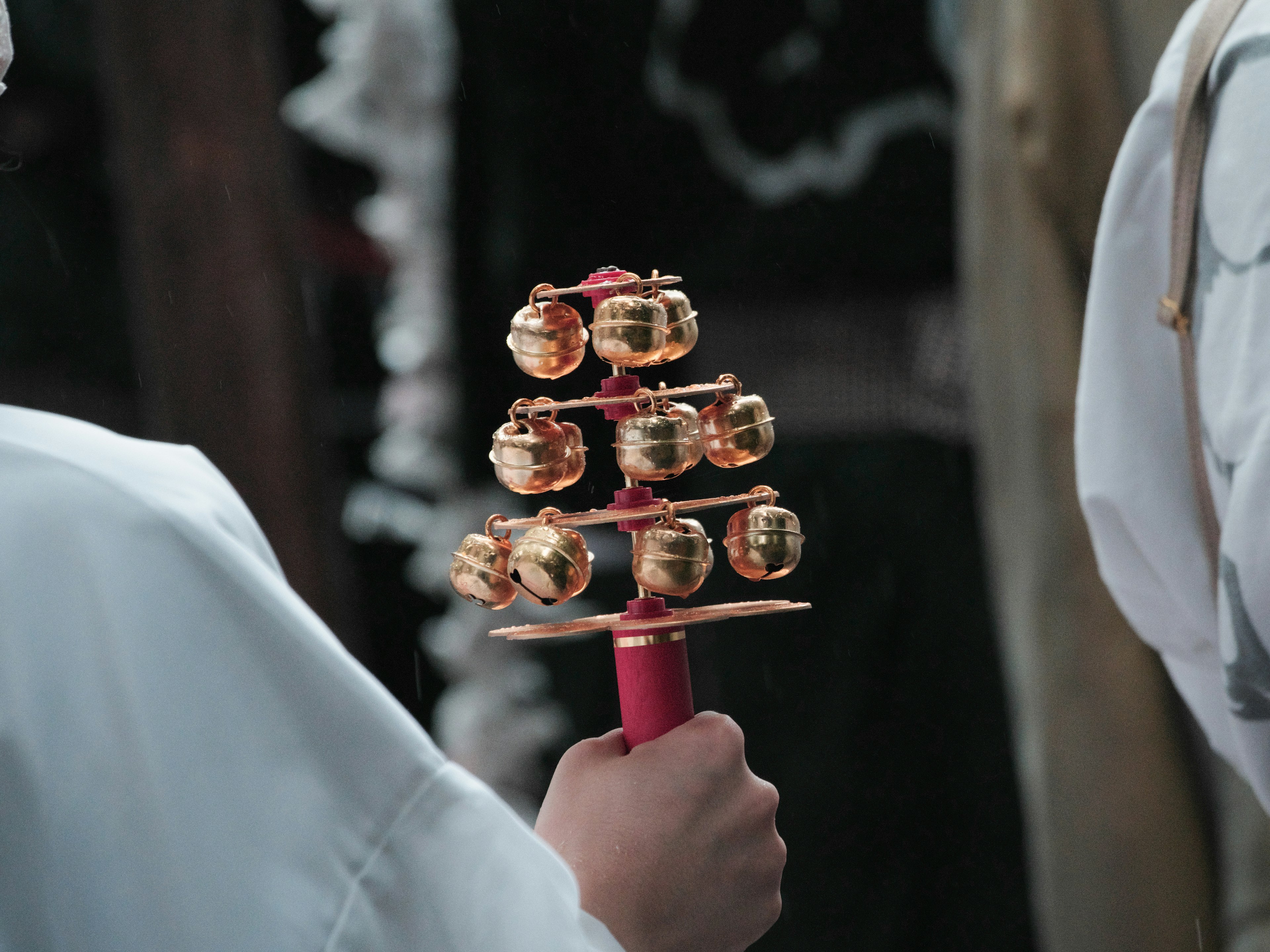 A toy with golden bells held in hand