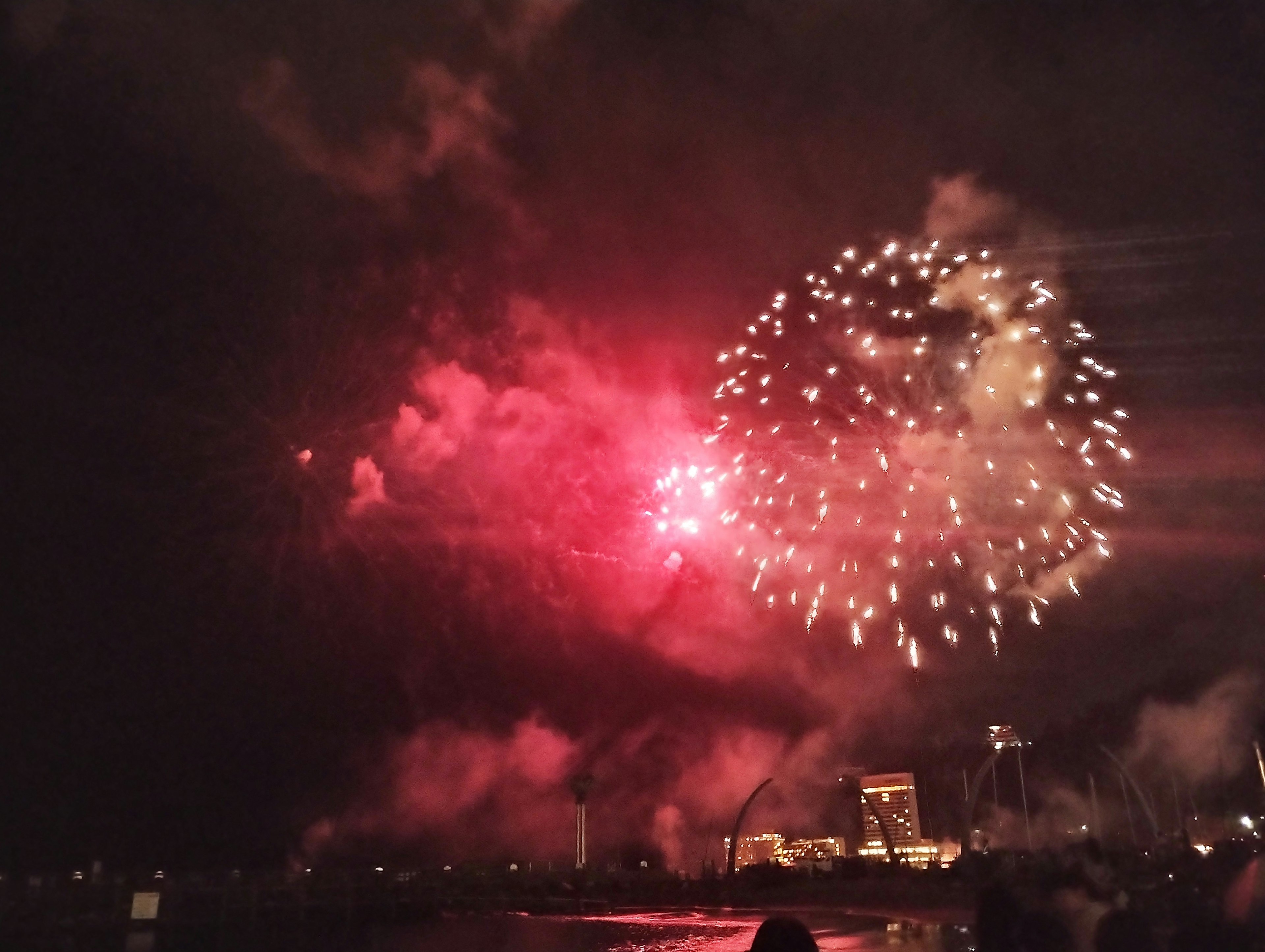 夜空に広がる赤い花火と煙