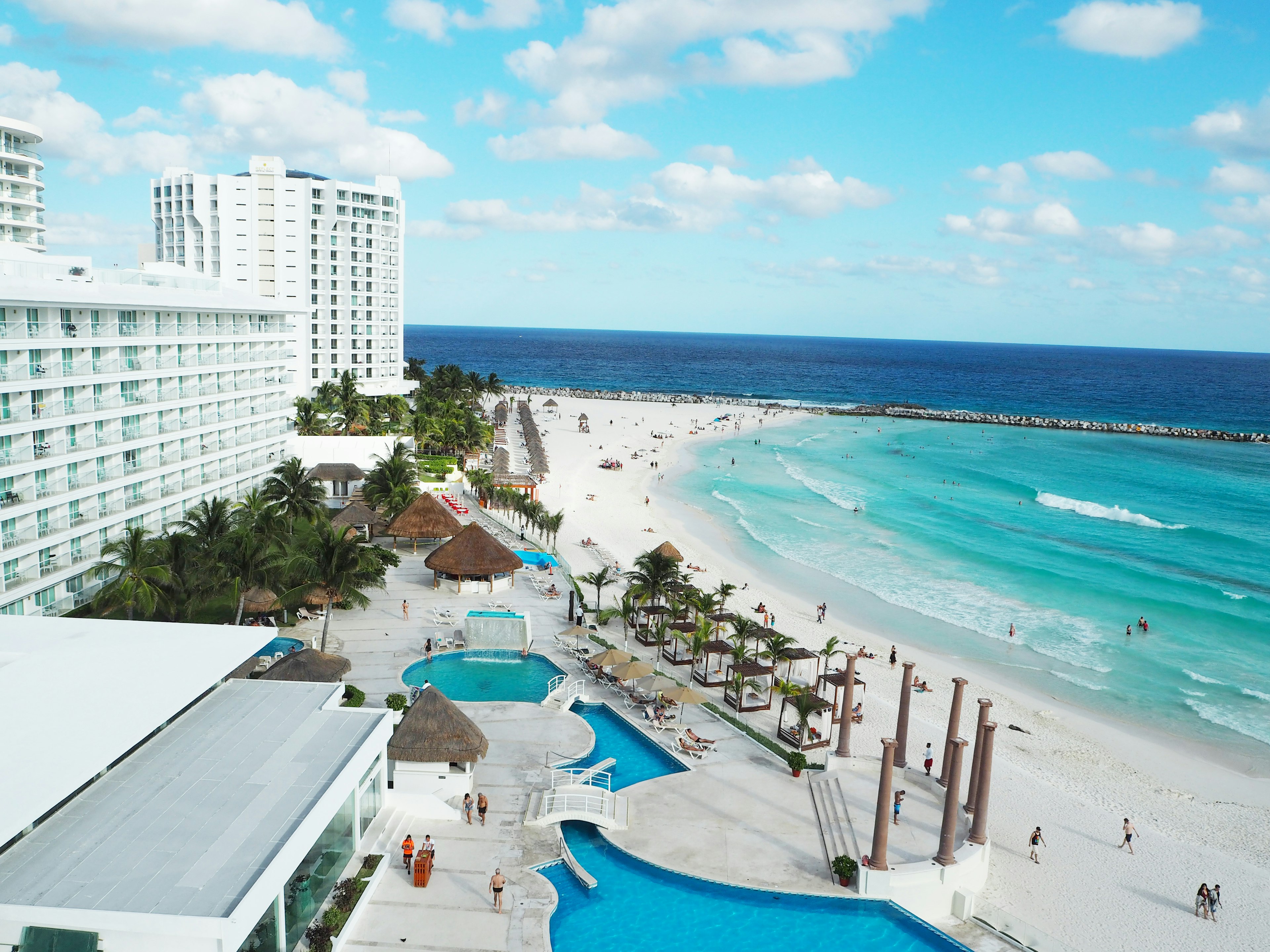 Aerial view of a beach resort with pools and ocean