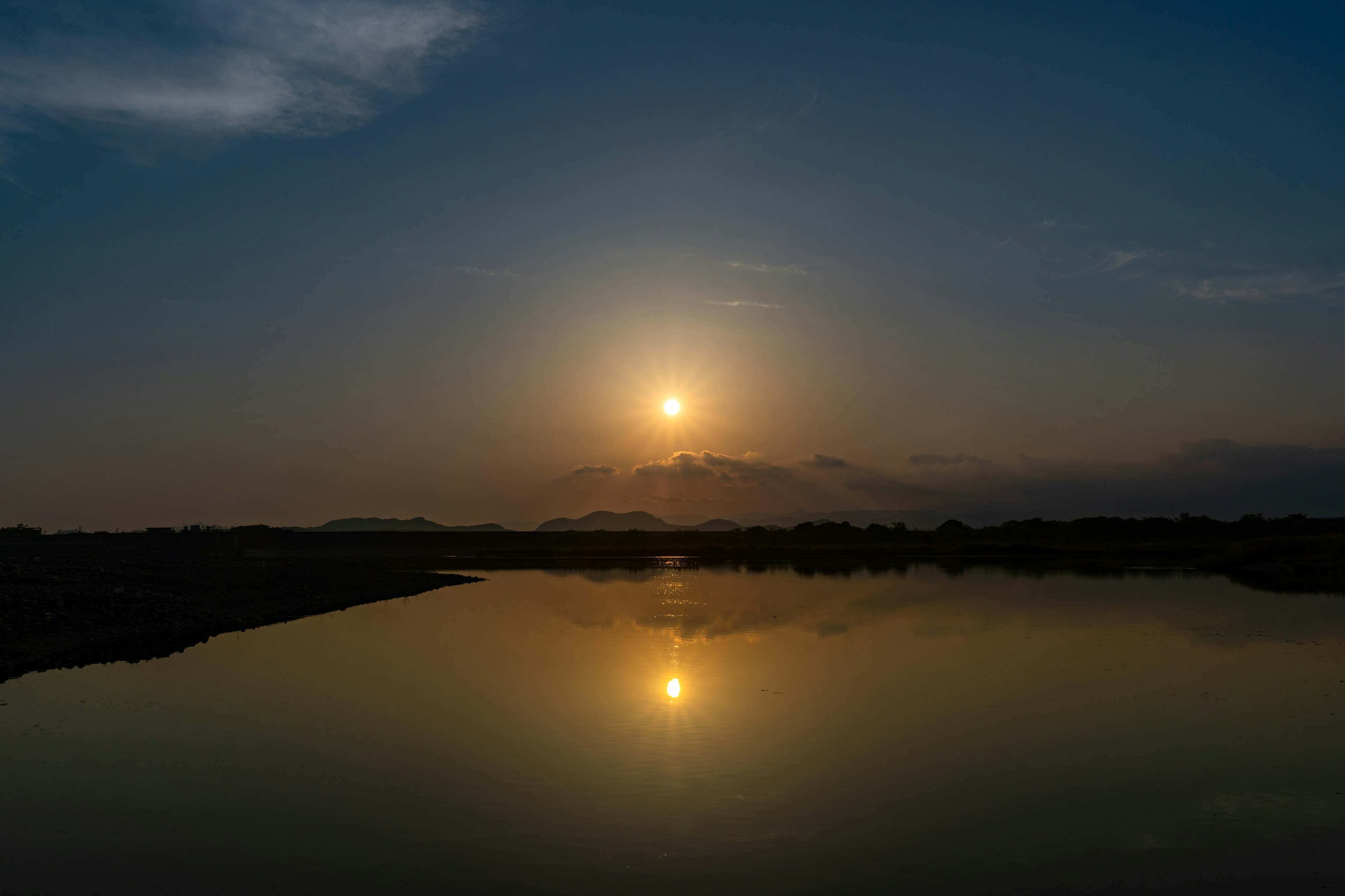 Atardecer reflejándose en agua tranquila