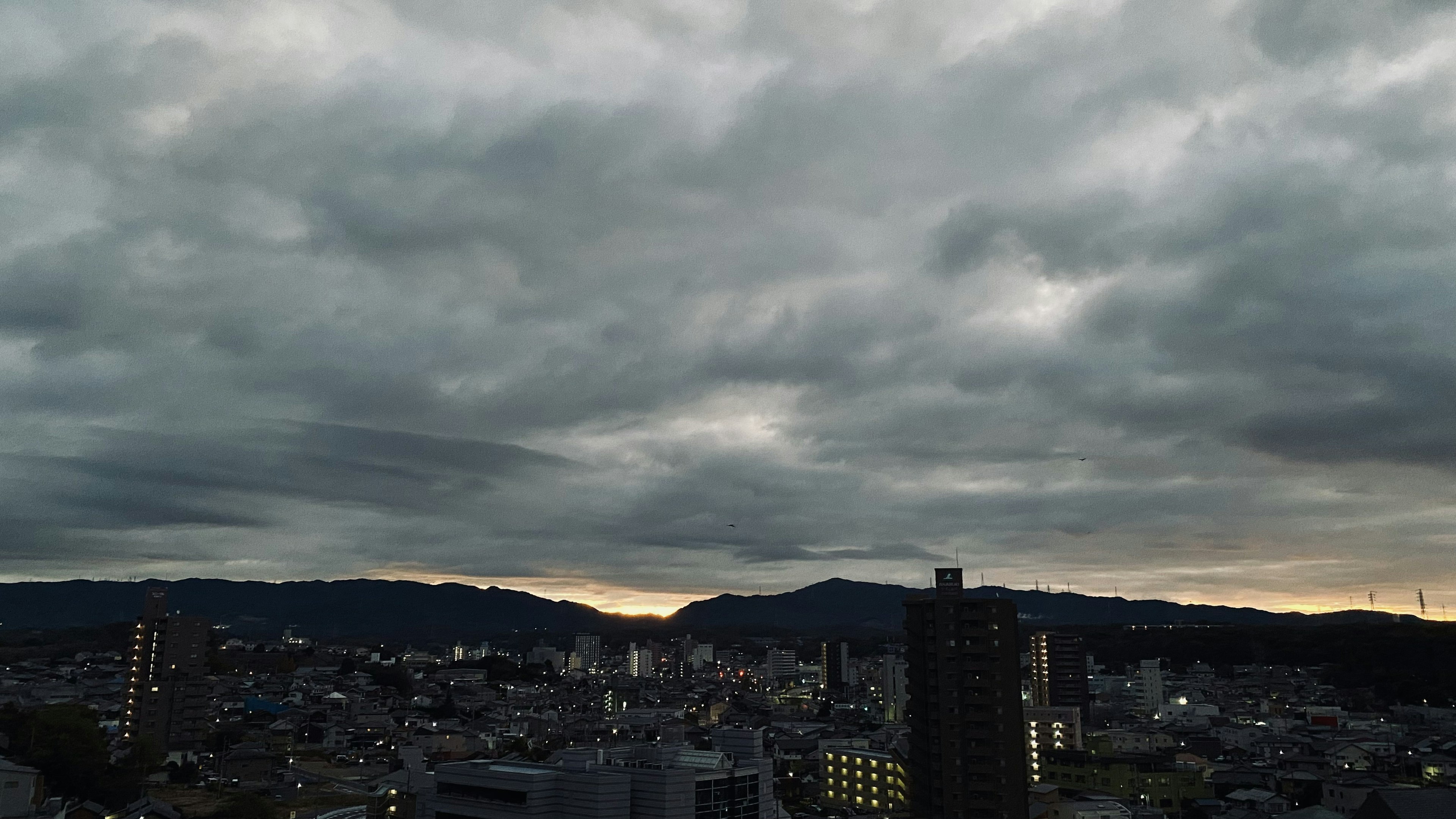 城市风景在多云的天空下，背景有山脉