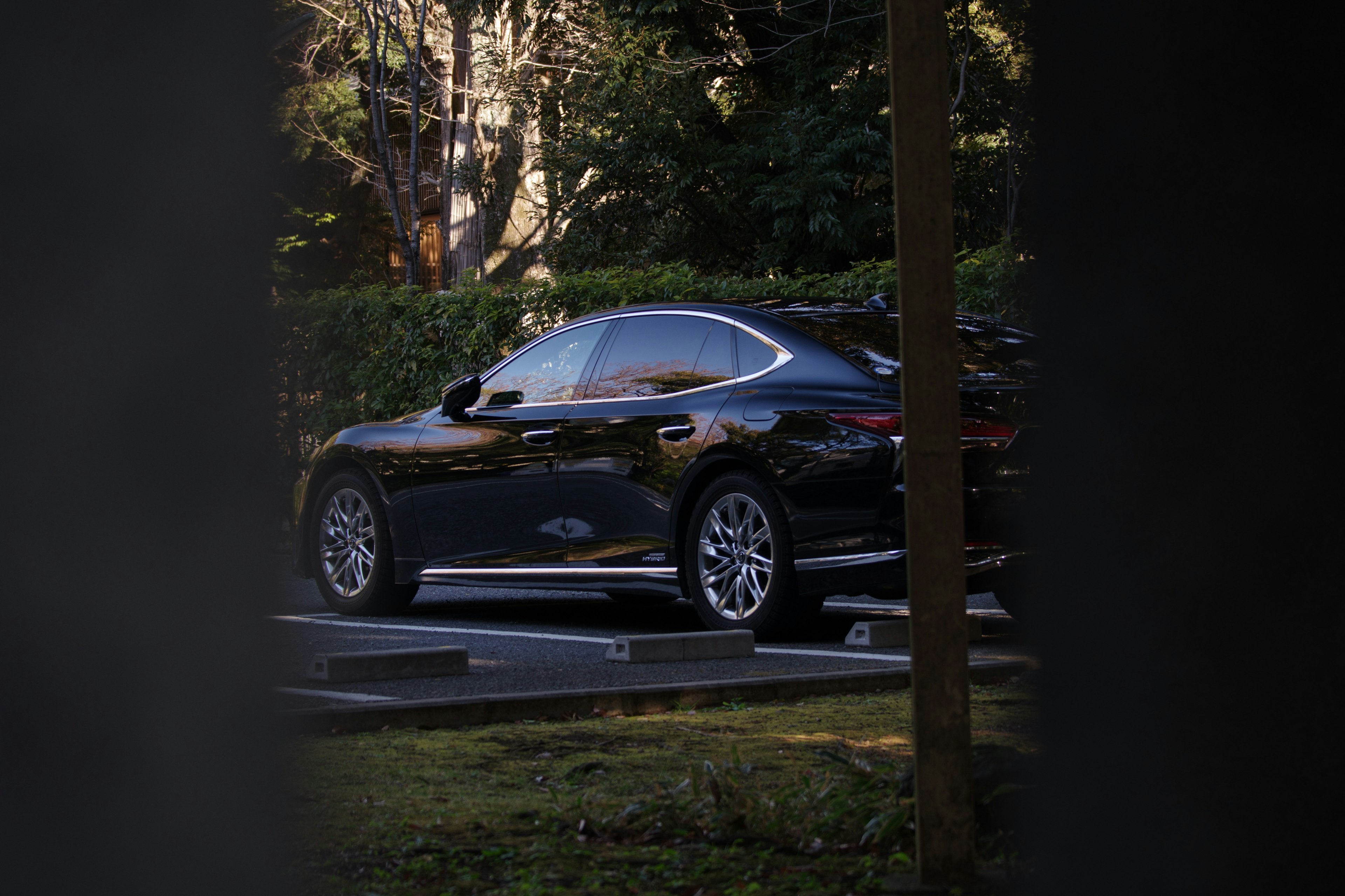 A black luxury car parked in a parking lot